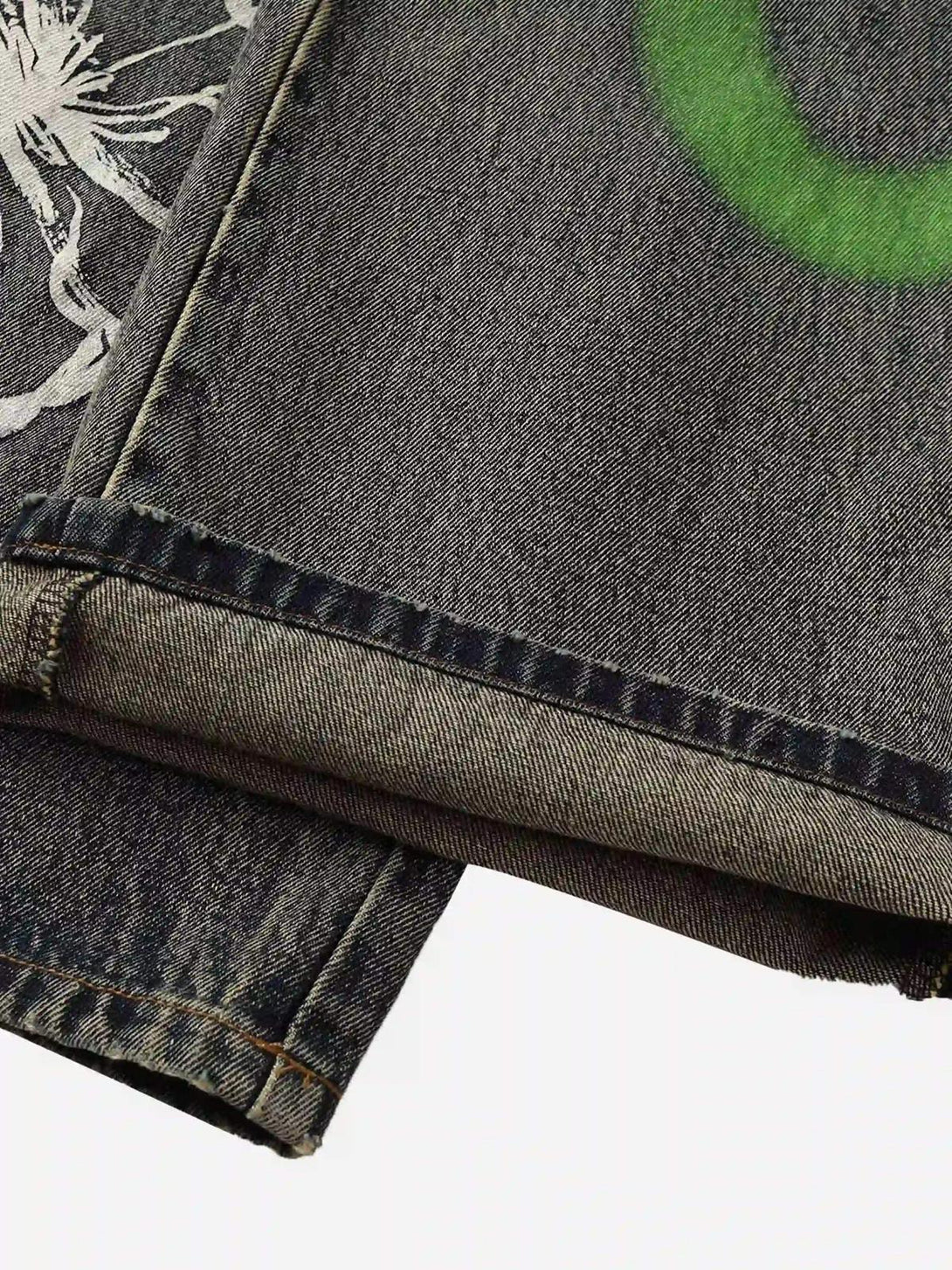 Zoomed-in texture of TALISHKO graffiti jeans, highlighting unique white floral and green designs.