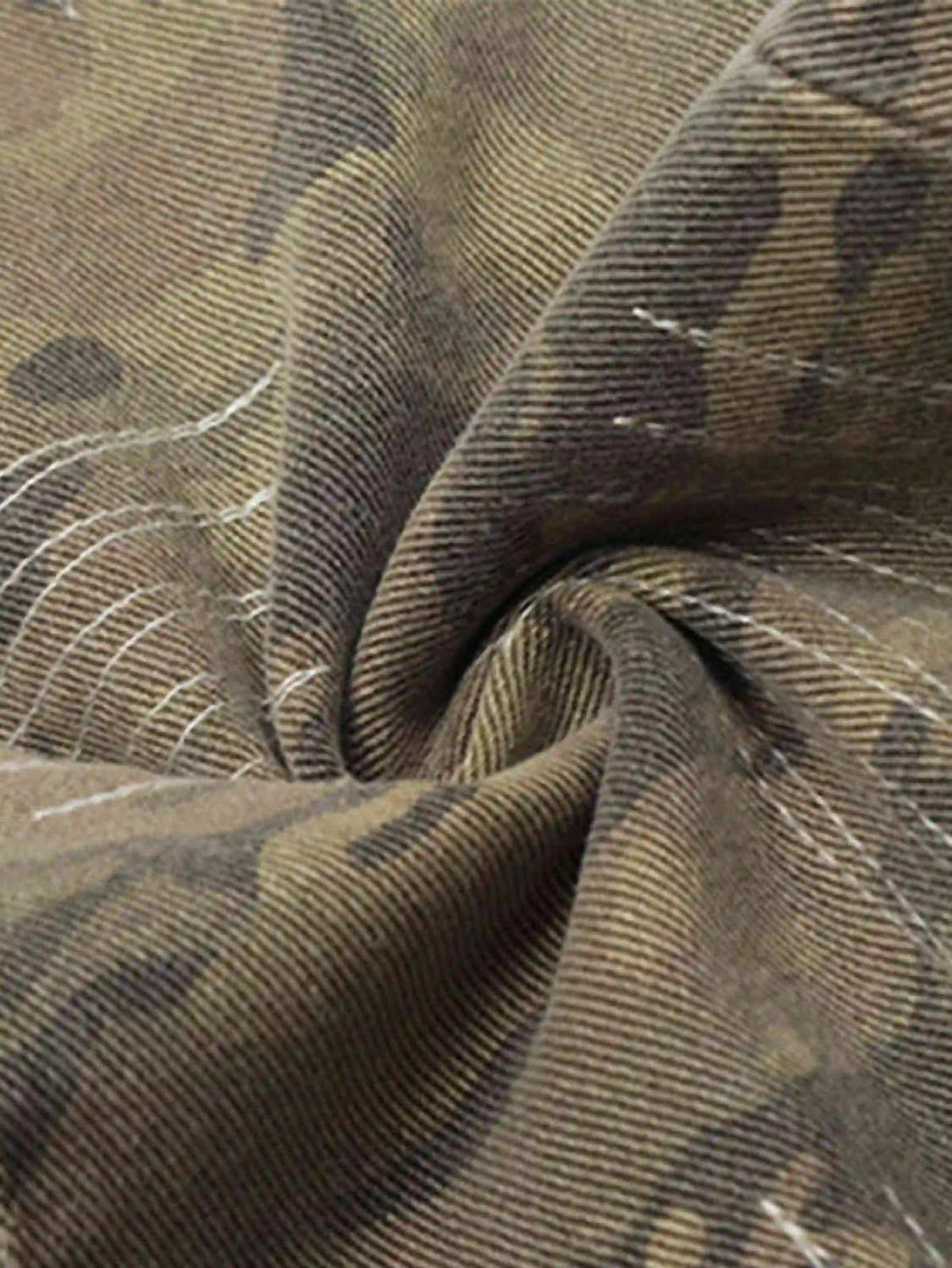 Detailed fabric and stitching of TALISHKO's hip hop jeans, featuring camo patterns.