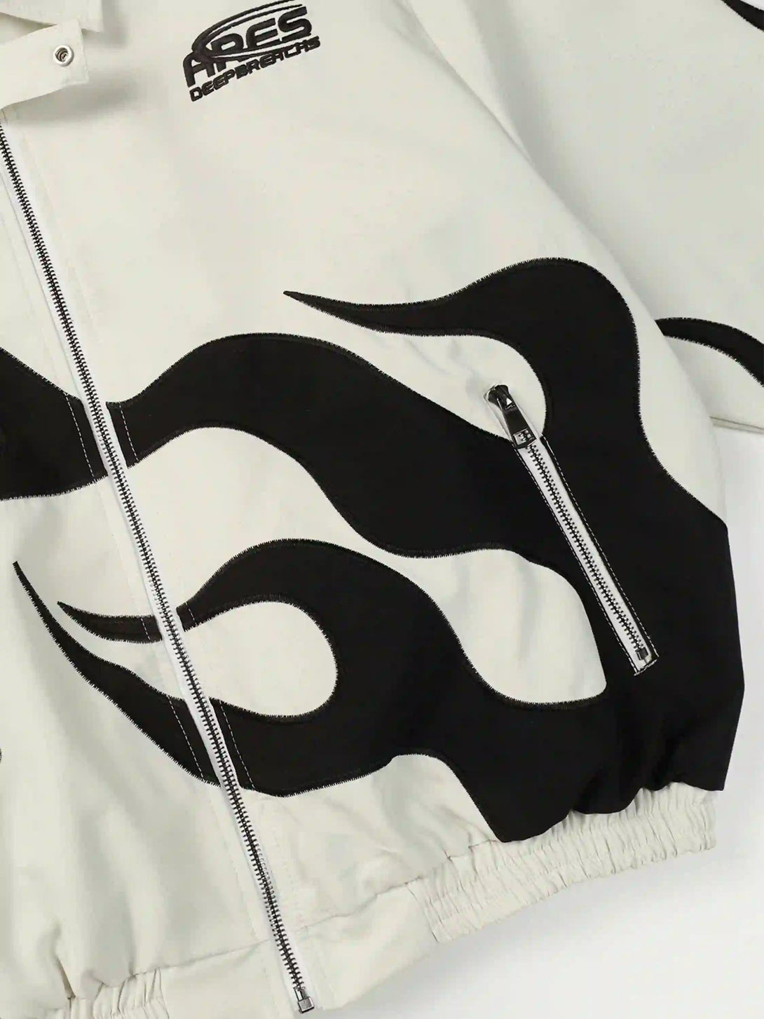 A detailed view of the flame pattern and zipper on a TALISHKO jacket, showcasing its edgy design.
