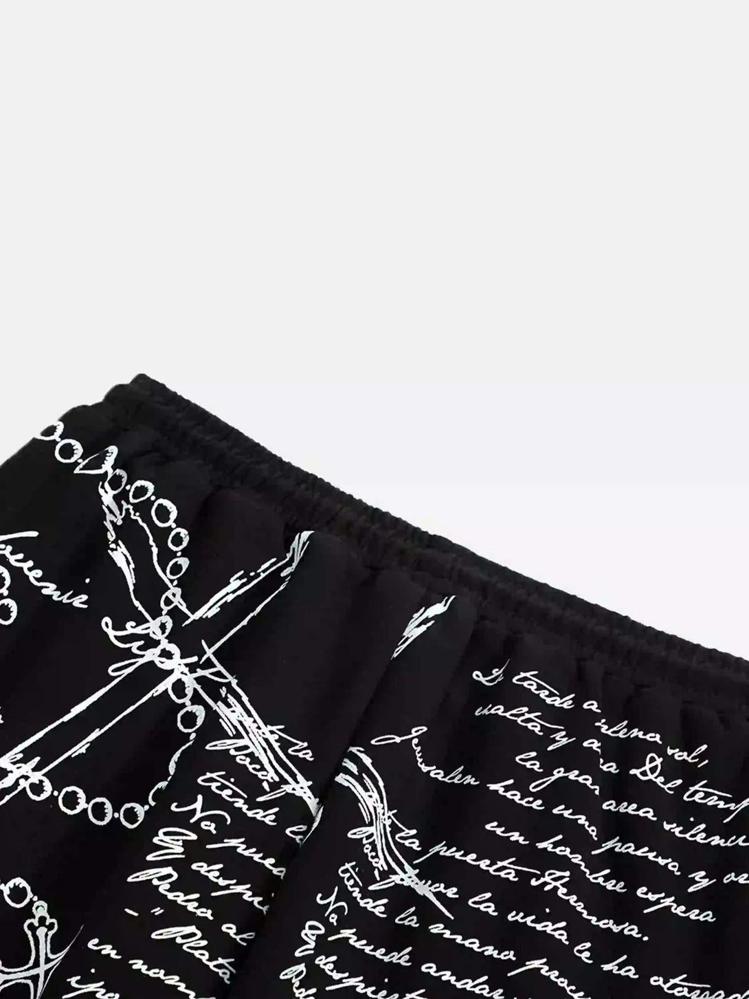 Intricate design on black hip-hop pants by TALISHKO, featuring expressive white script.