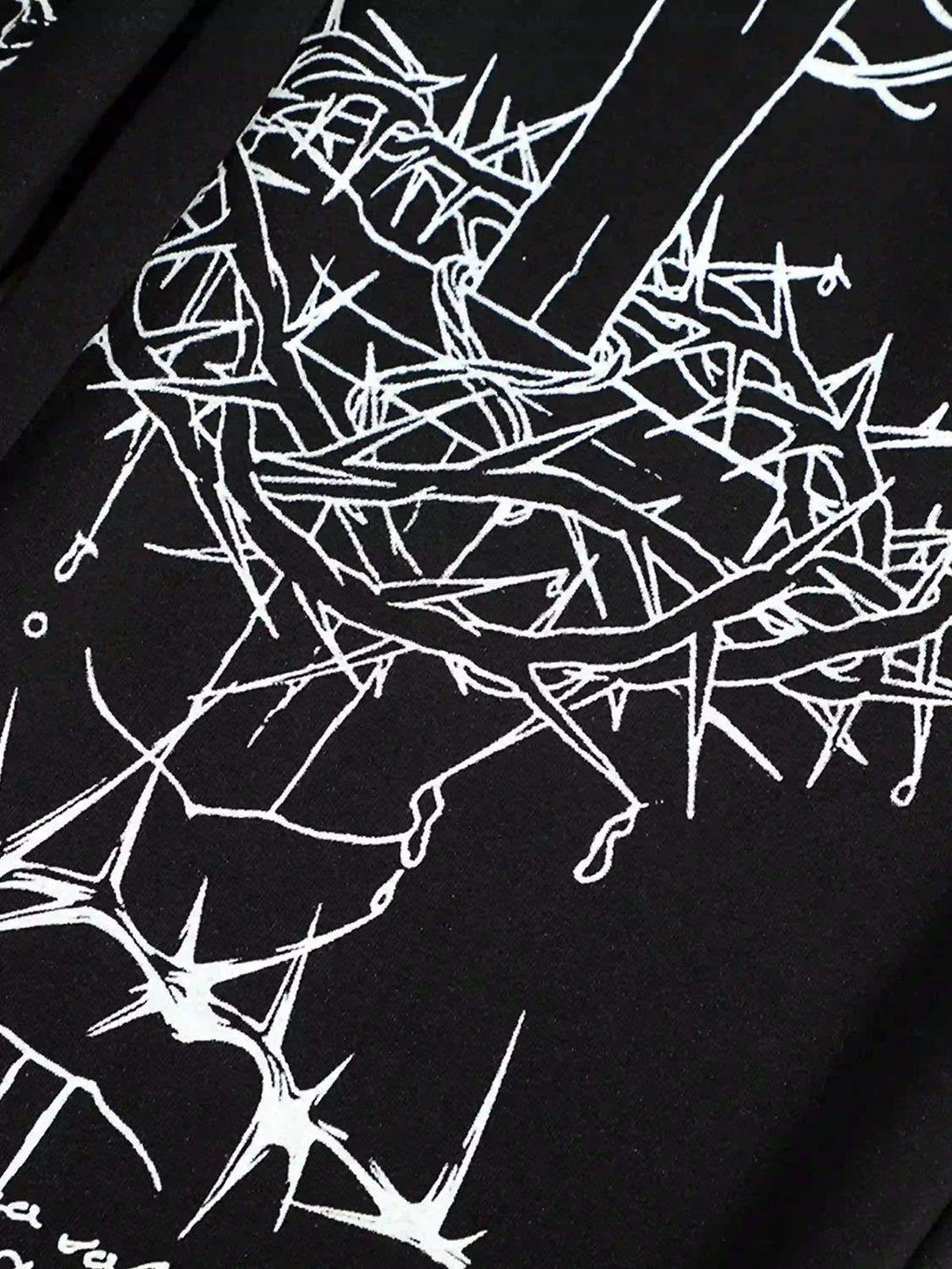 Intricate look at TALISHKO hip-hop pants, focusing on expressive white designs against black fabric.