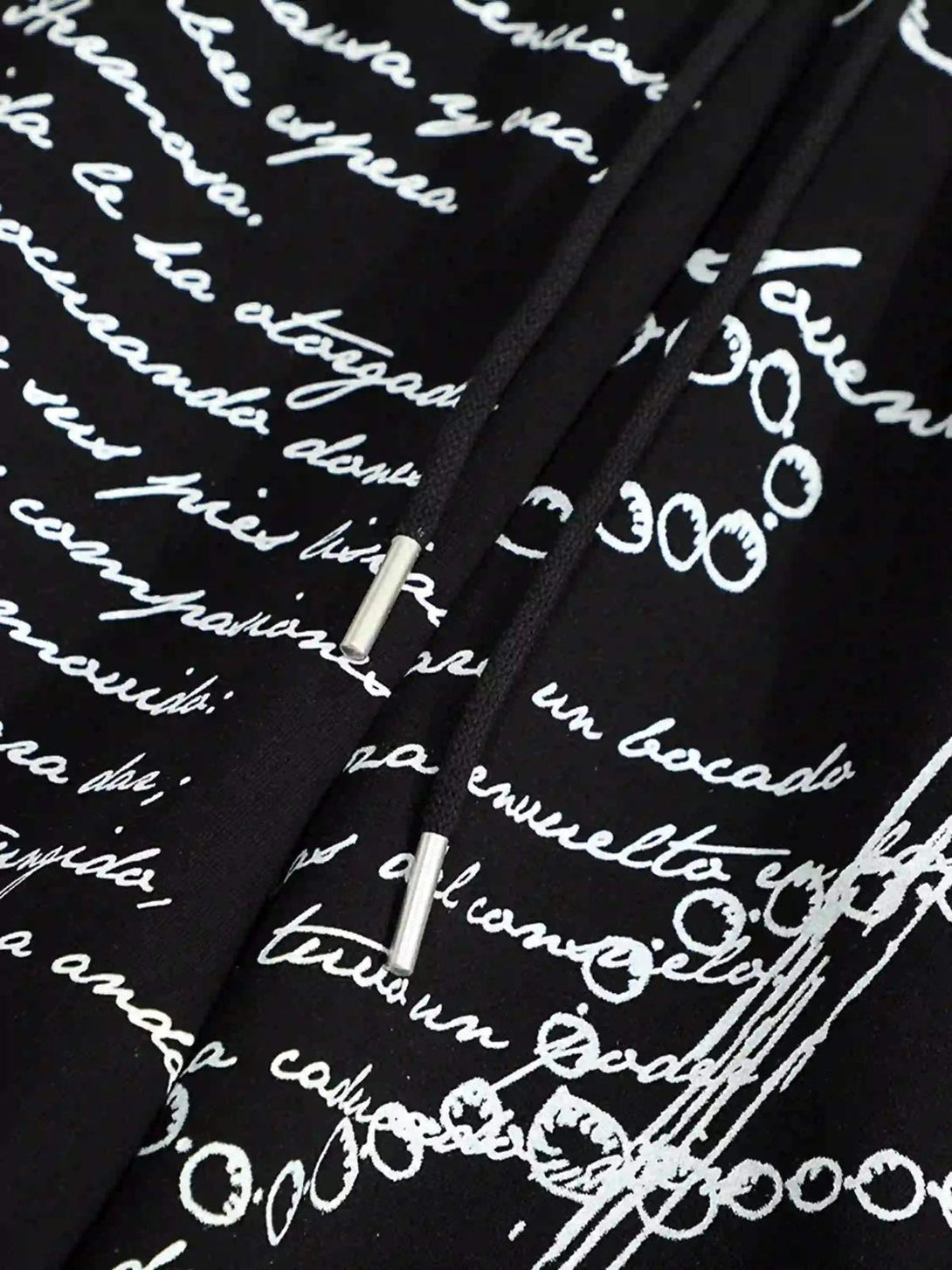 Intricate detailing on TALISHKO hip-hop pants, featuring expressive white script on black fabric.