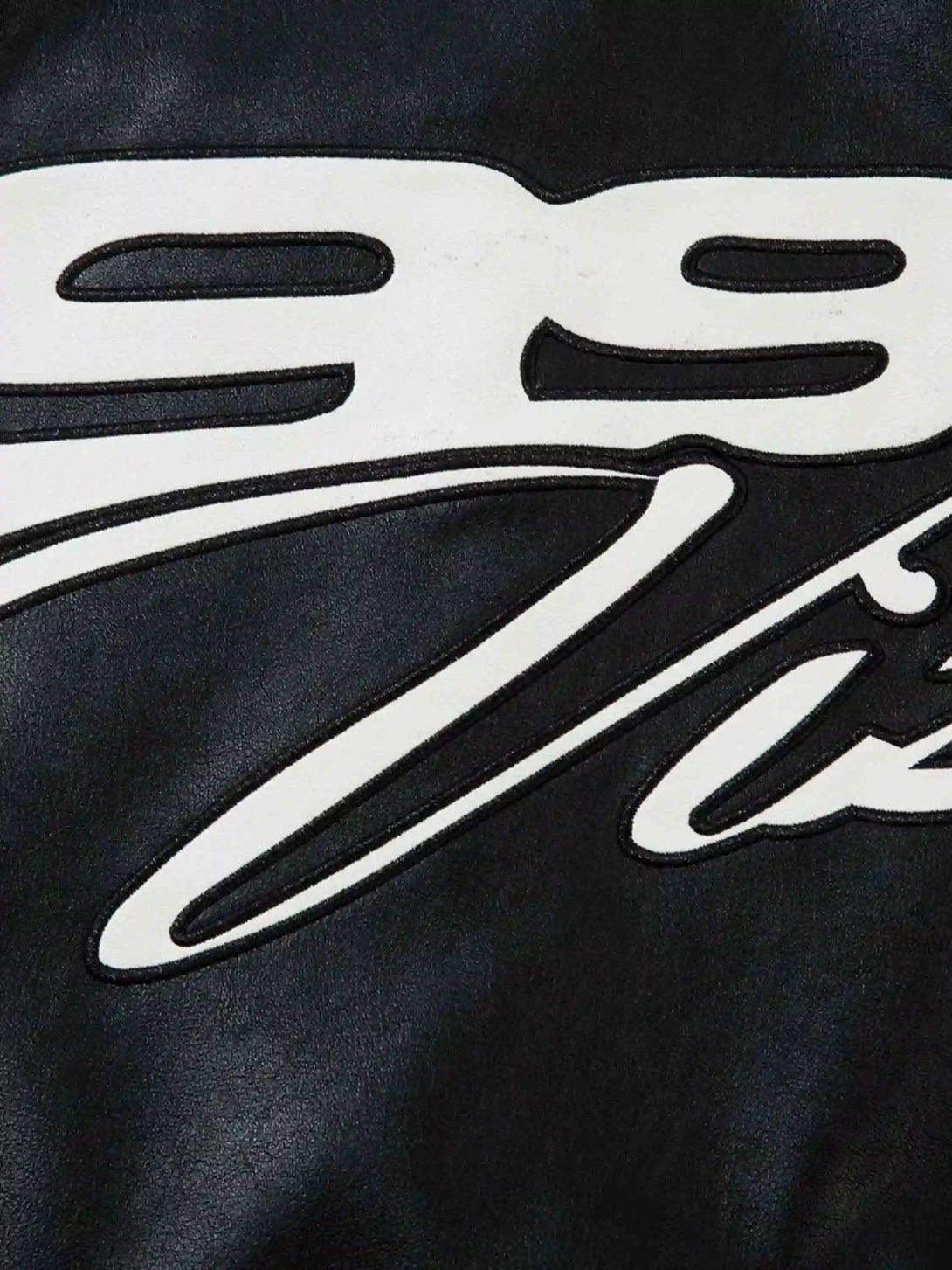"Zoomed-in view of TALISHKO's motorcycle jacket, highlighting bold hip-hop graphics and texture."