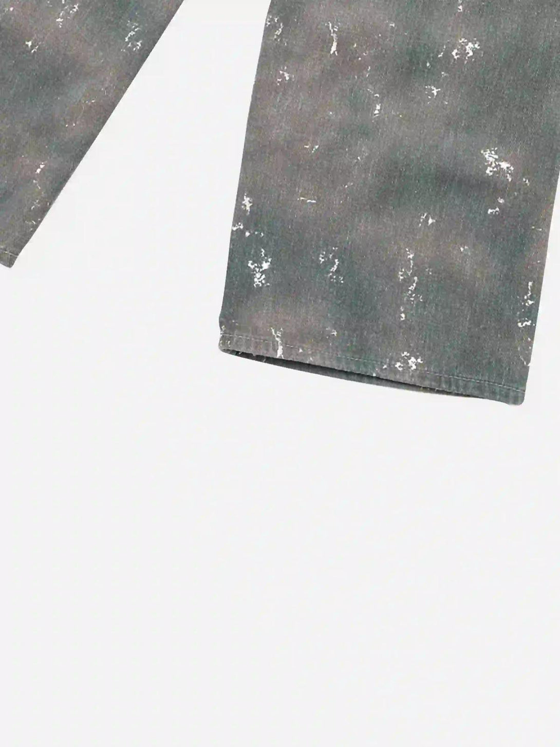 Zoomed-in view of TALISHKO's ink-splashed jeans, showcasing unique camouflage texture.