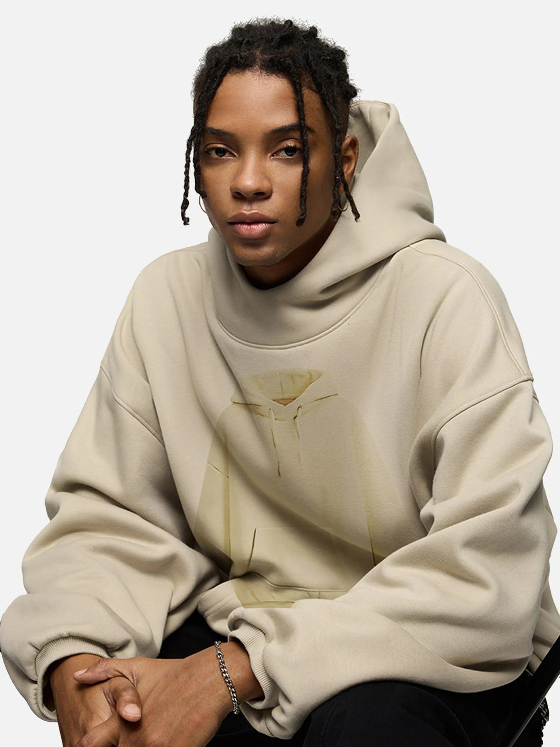 Model in a beige TALISHKO hoodie with a subtle graphic design, showcasing casual style.