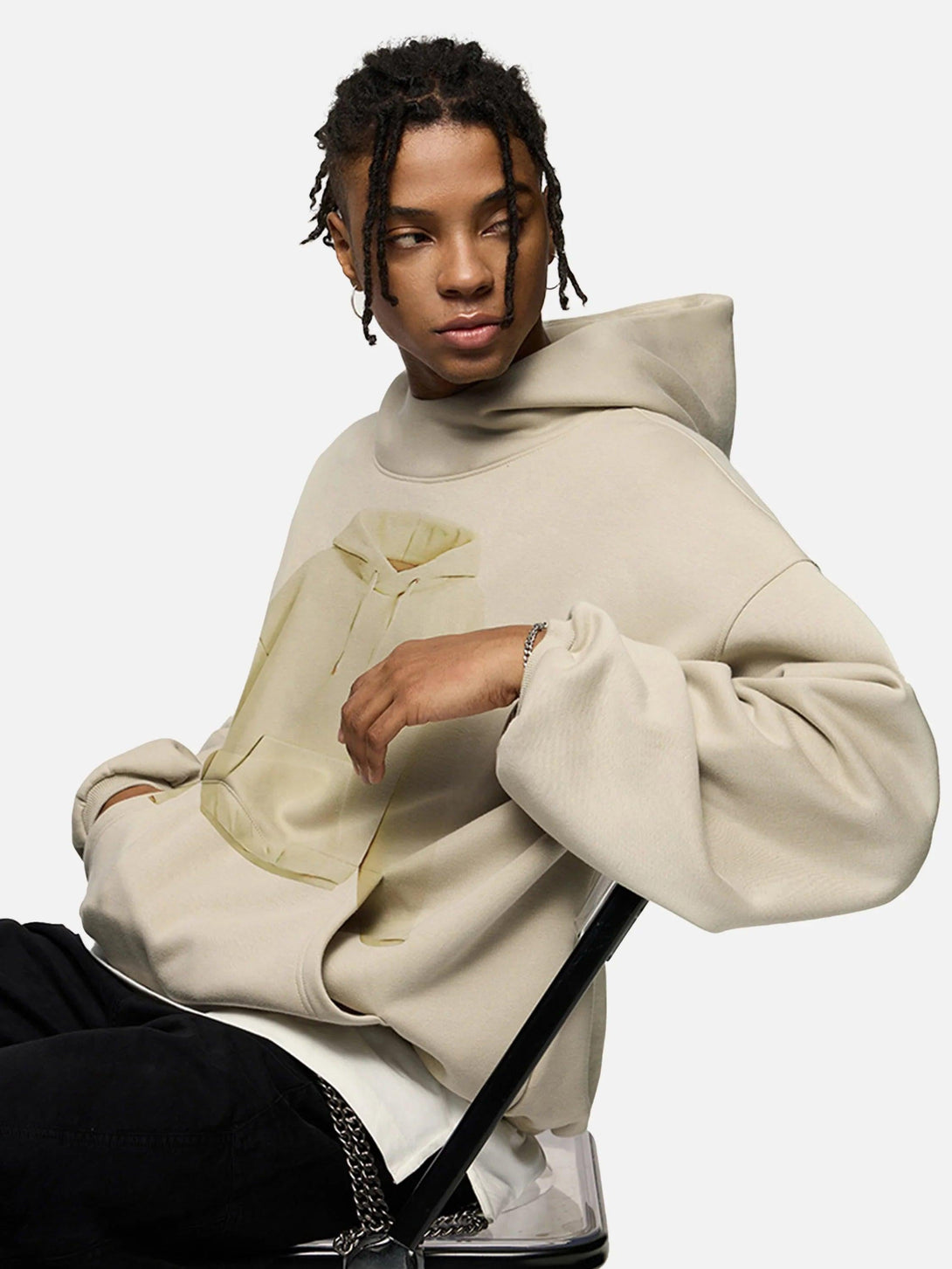 Model in a beige TALISHKO hoodie with a unique front graphic, exuding casual flair.