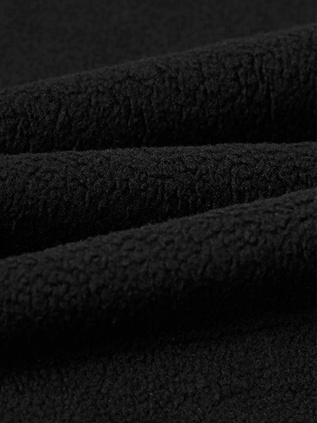 Zoomed-in texture of a black TALISHKO hoodie, highlighting its soft, cozy fabric.