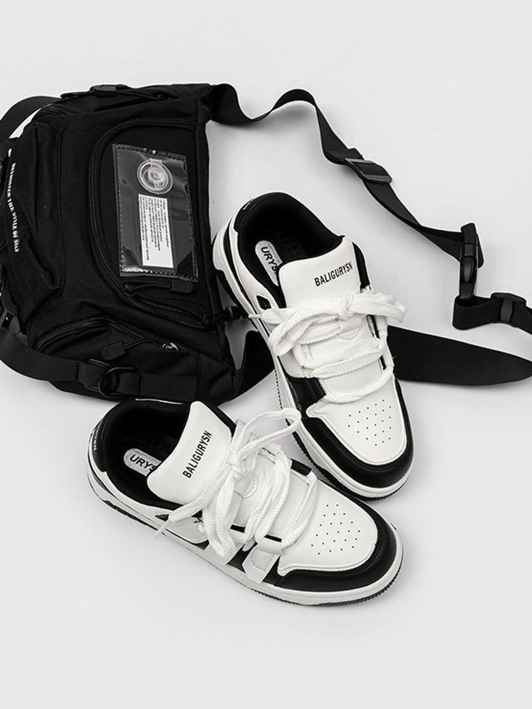 TALISHKO black and white sports shoes with a sleek bag, highlighting modern street style.