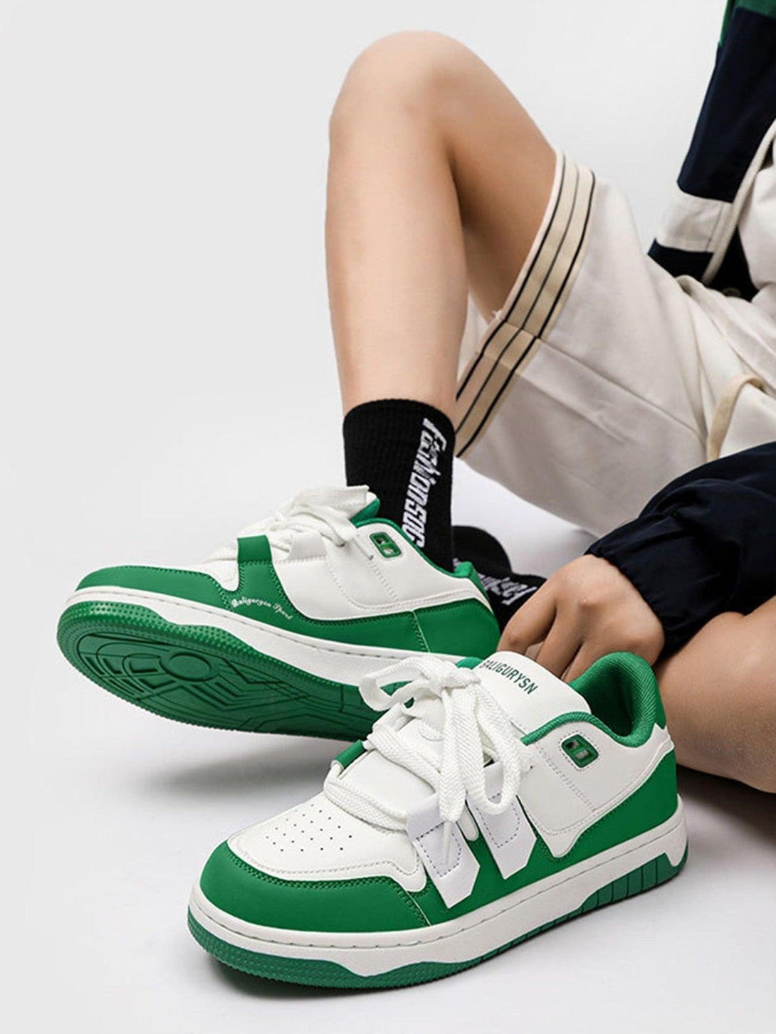 Casual board shoes by TALISHKO in green and white, styled with sporty shorts and socks.