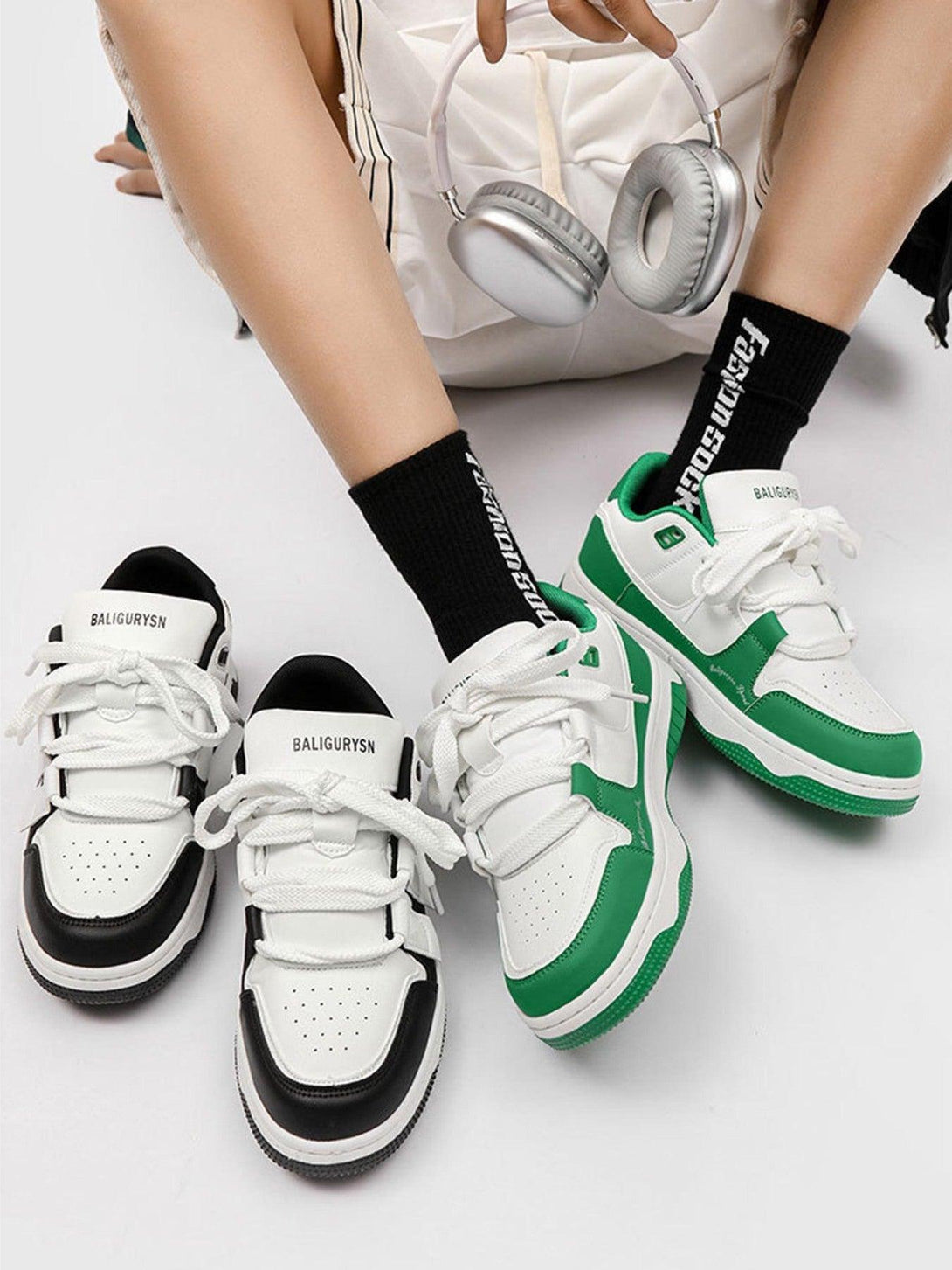 TALISHKO black and white sports shoes paired with black socks and headphones for a trendy look.