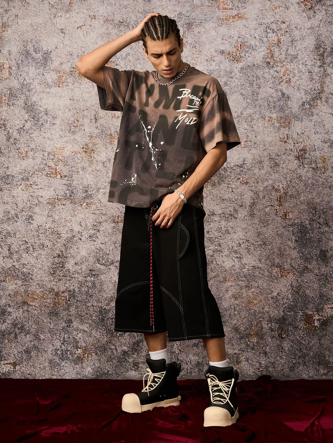 Model wearing TALISHKO ink splash letter print T-shirt and wide black shorts, showcasing urban flair.
