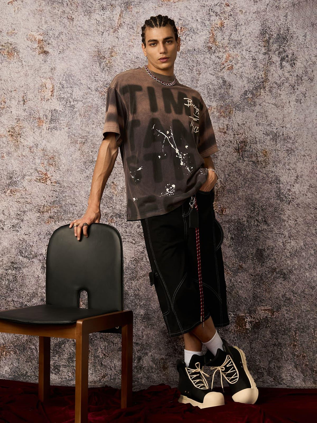Model wearing TALISHKO ink splash letter print T-shirt, paired with bold black shorts and sneakers.