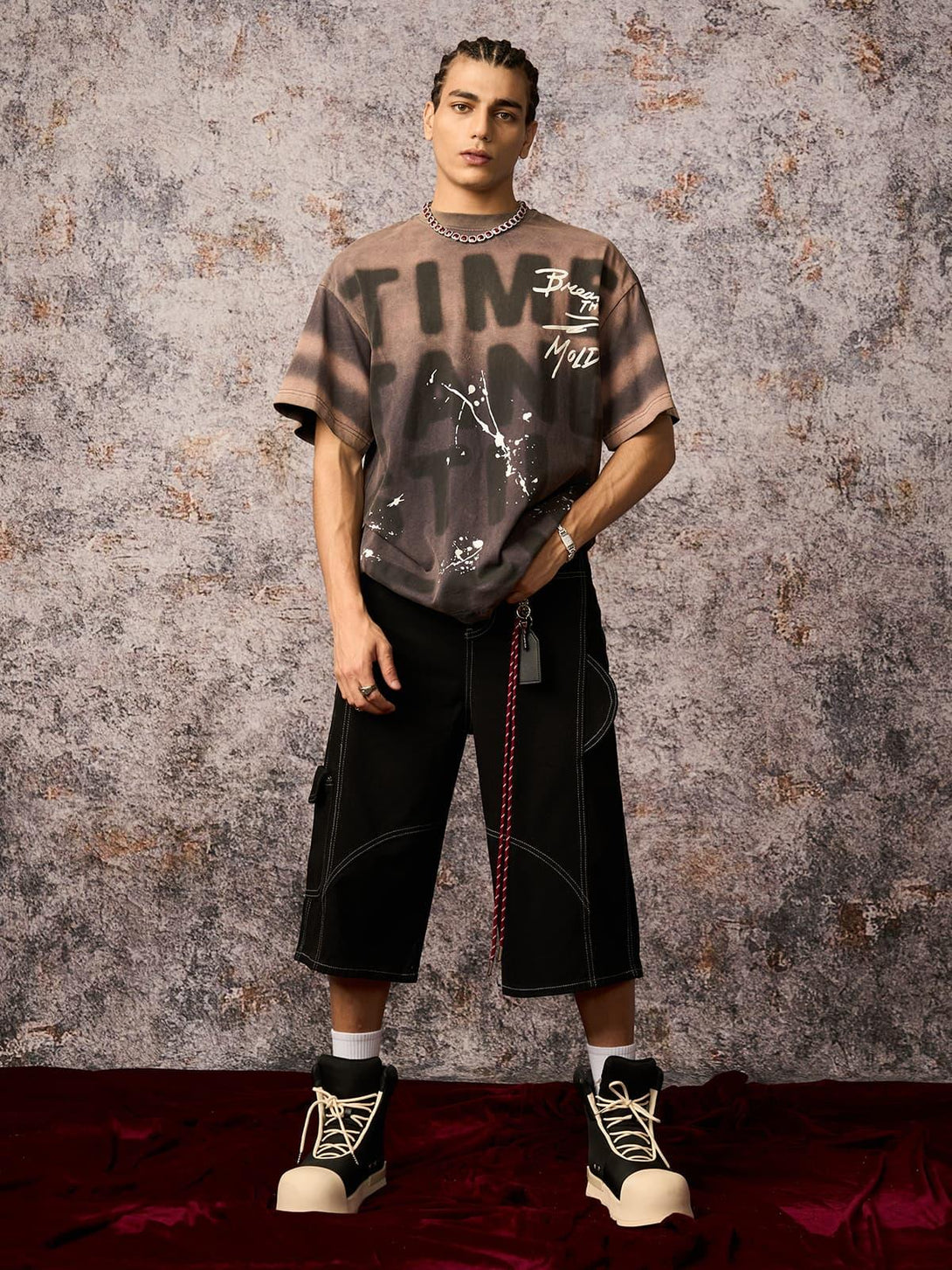 Model wearing TALISHKO ink splash letter print T-shirt and black shorts, highlighting bold urban style.