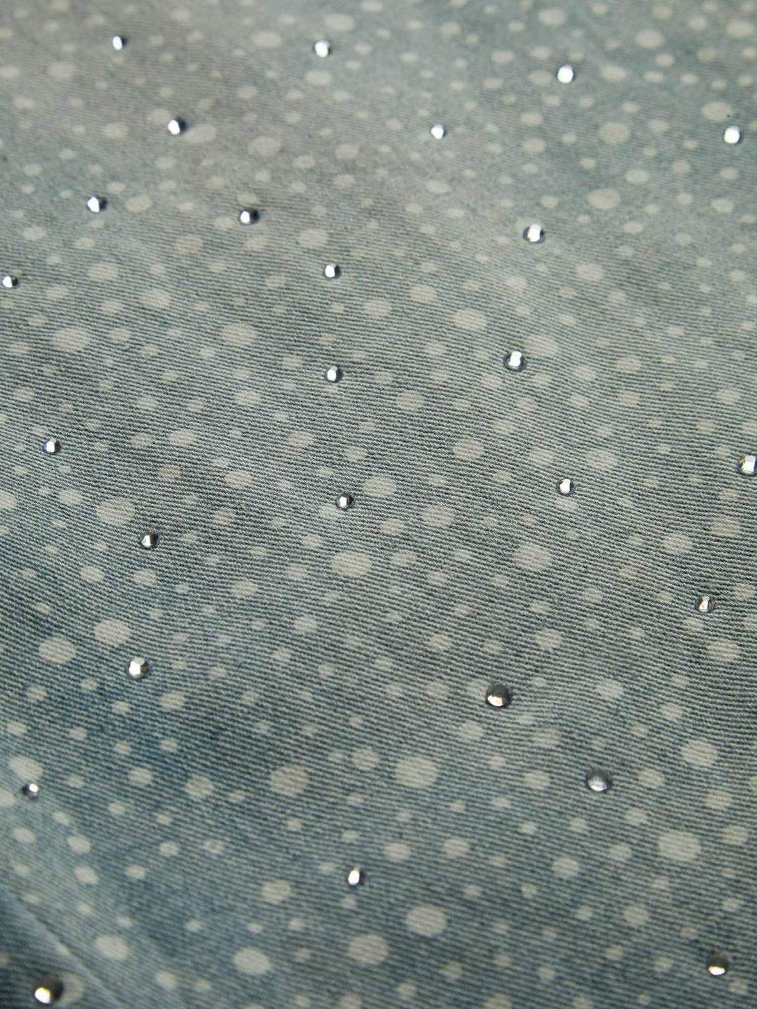 Texture and rhinestone pattern highlighted on TALISHKO's ink-splashed baggy jeans fabric.