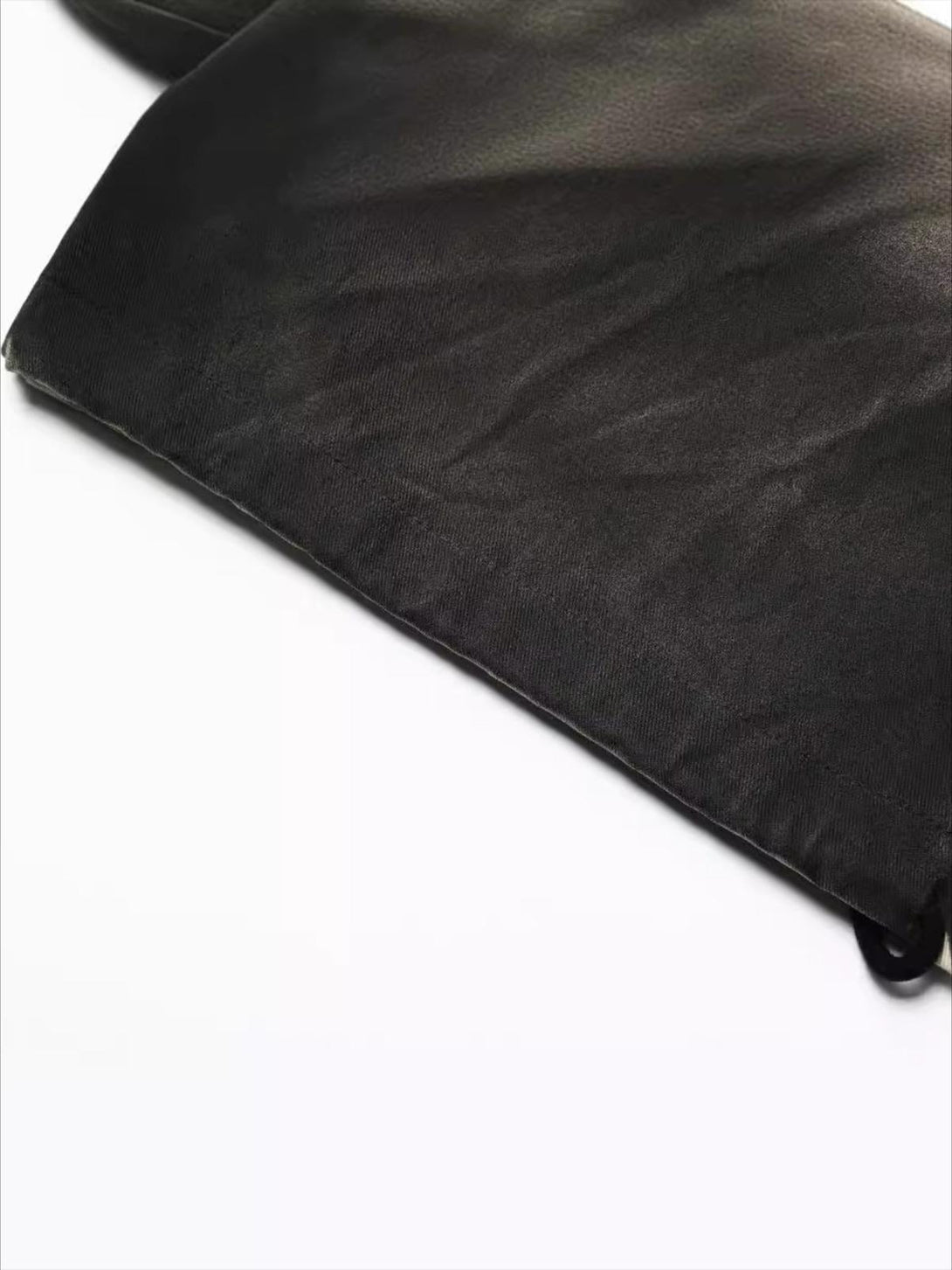 A close-up of TALISHKO's inkjet pleated pants, highlighting the rich fabric texture.