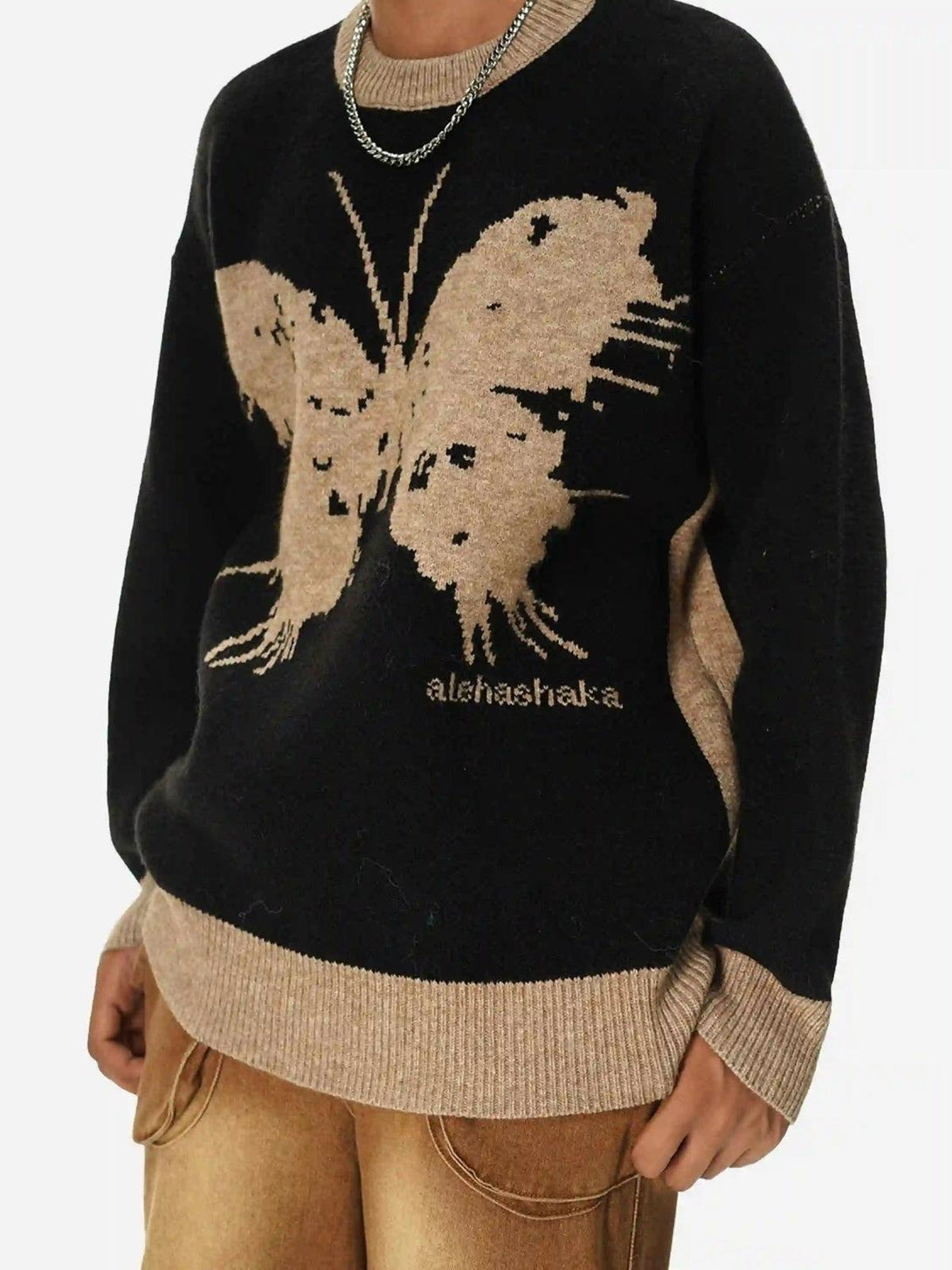 Model in a TALISHKO jacquard butterfly sweater paired with tan pants, highlighting casual style.