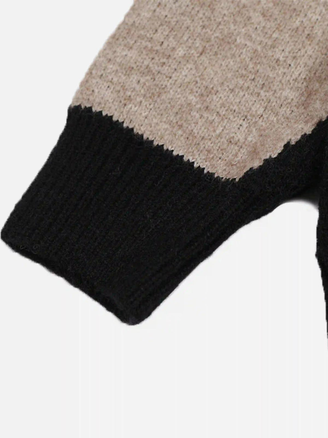 A detailed look at the sleeve of a TALISHKO sweater, highlighting the beige and black knit design.