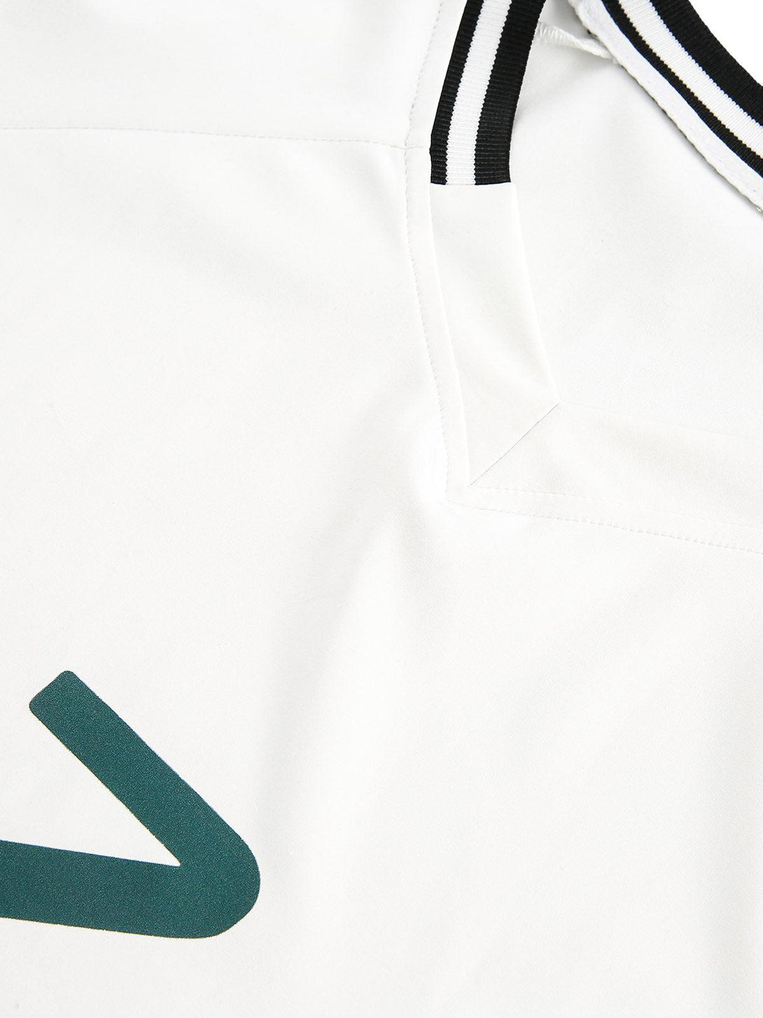 Tight crop highlighting contrast stitching and fabric details on a TALISHKO jersey.