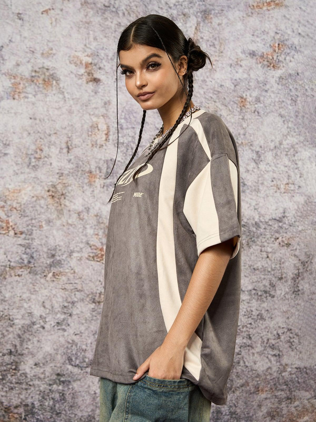 Model in a TALISHKO T-shirt with contrast color stitching and deconstructed design.