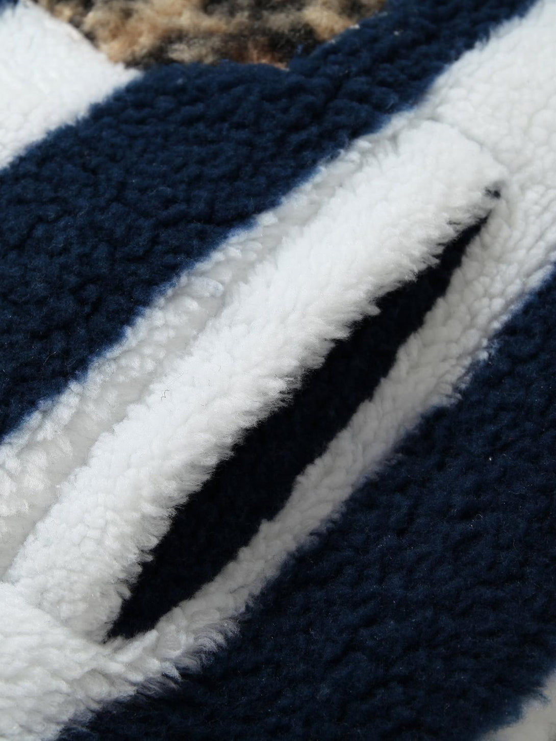 Focusing on TALISHKO's sherpa fabric, highlighting plush texture and bold striped pattern.