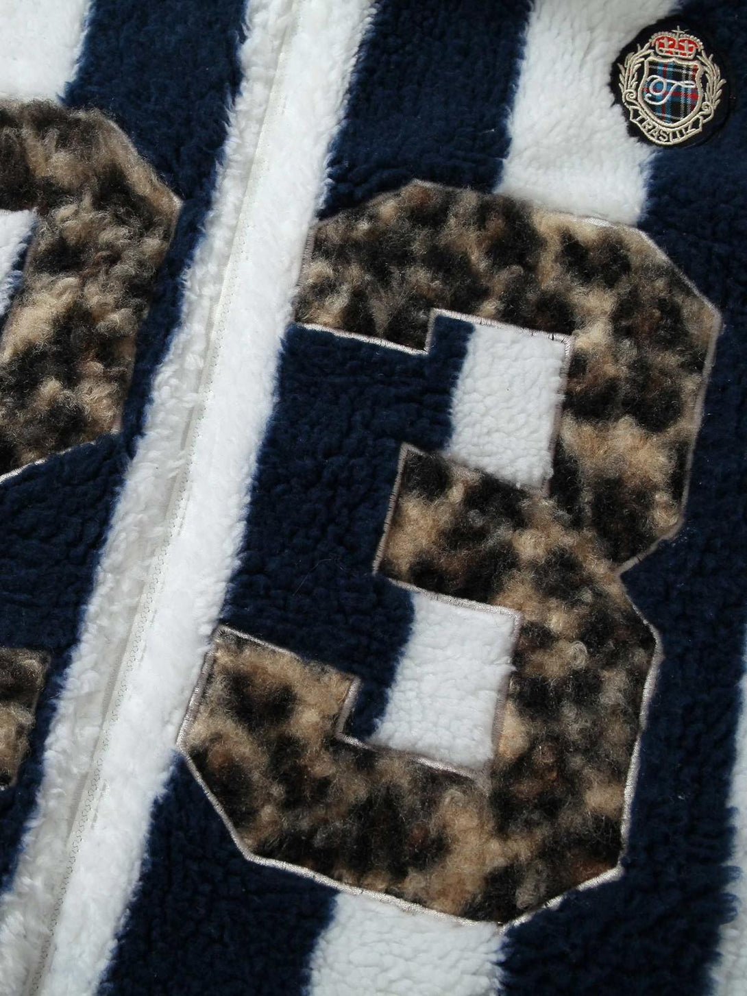 Zoomed-in view of TALISHKO's sherpa jacket showcasing embroidered cheetah print and stripes.