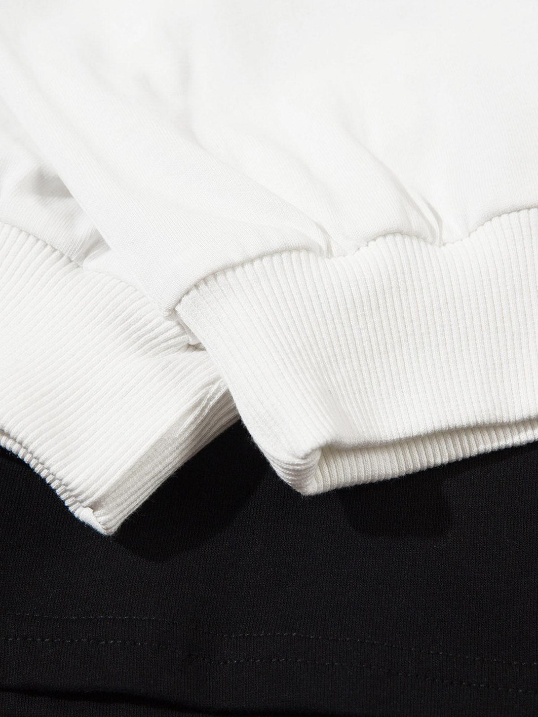 Focusing on the ribbed cuffs of a TALISHKO jersey long sleeve shirt in black and white.