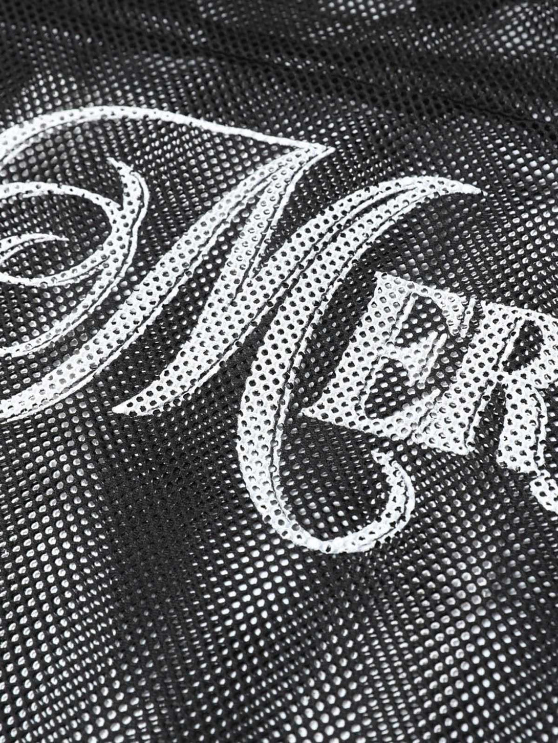 A close-up of TALISHKO's black mesh jersey blouse featuring intricate "MERVIN" script detail.