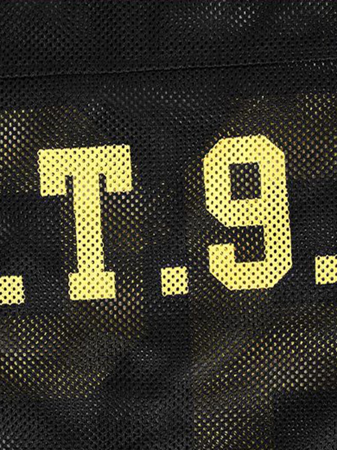 A detailed view of yellow lettering on black mesh fabric by TALISHKO, perfect for casual vibes.
