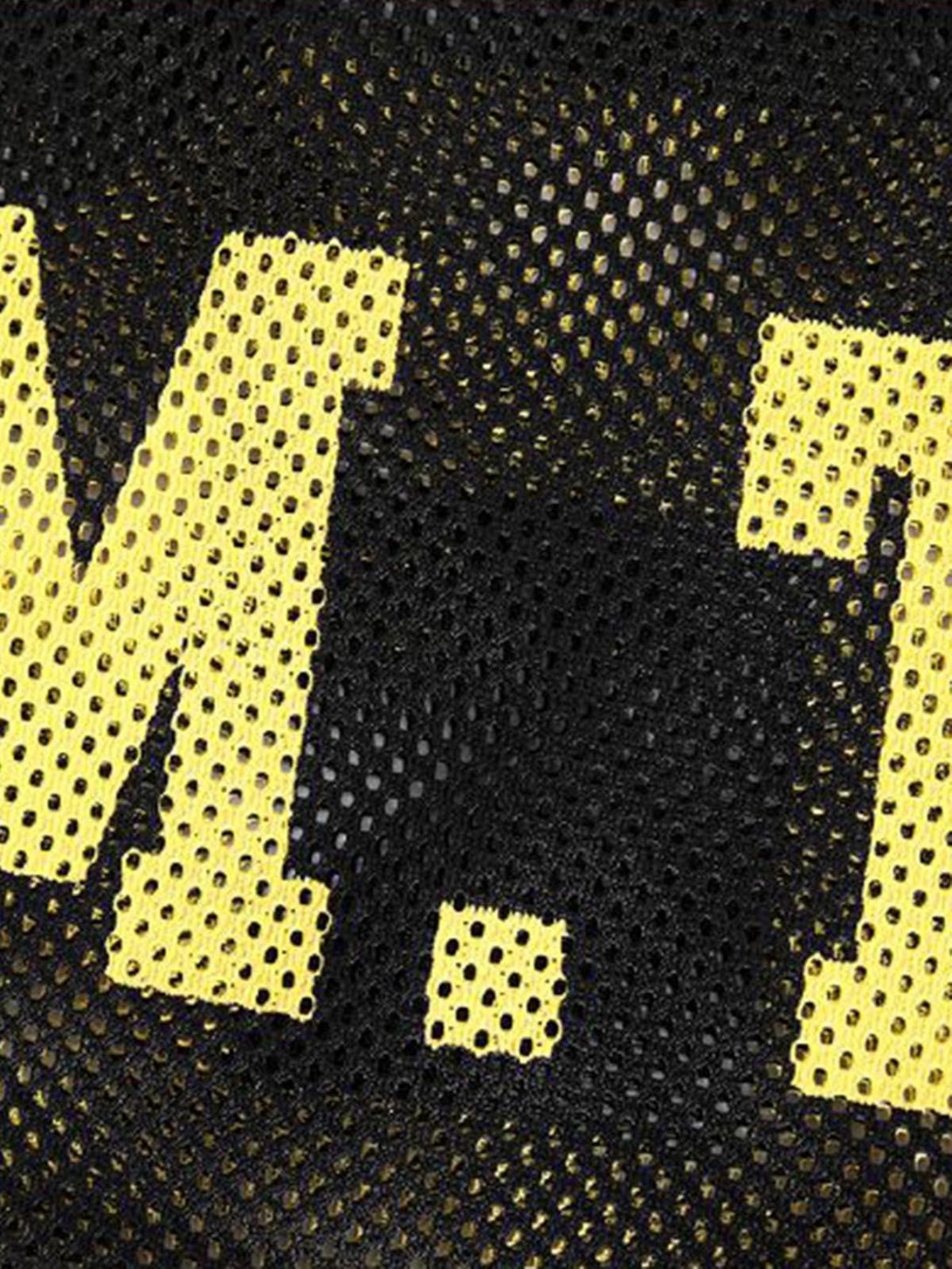 Zoomed-in texture of black mesh fabric with yellow lettering by TALISHKO.