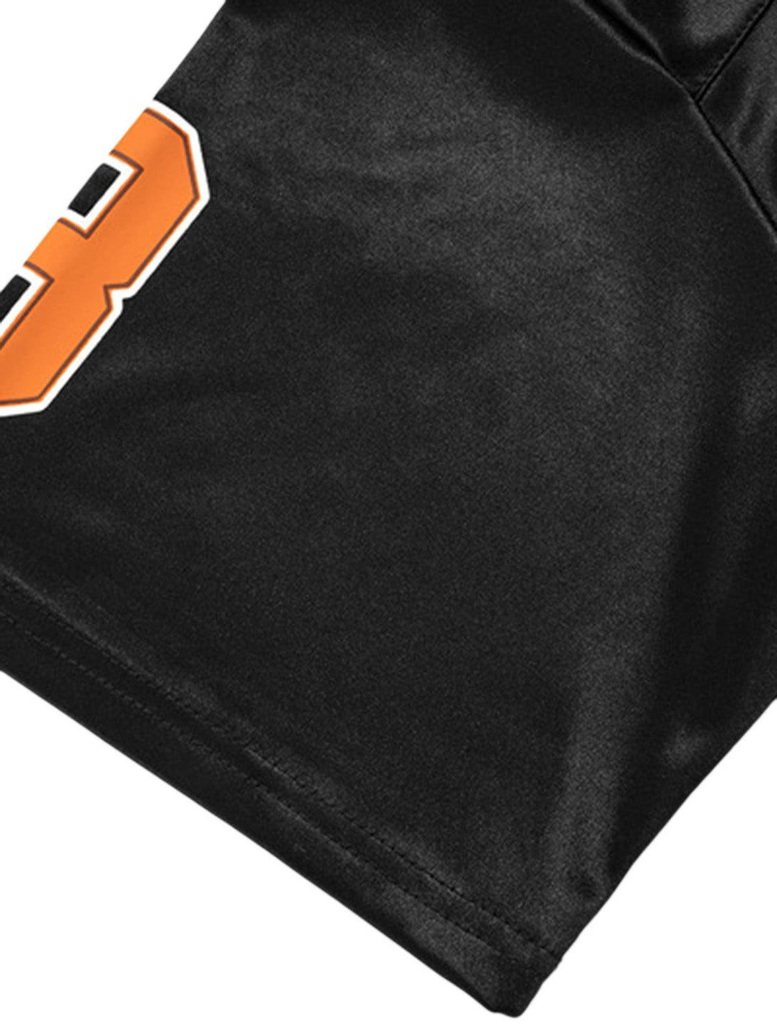 "Focusing on the intricate stitching of TALISHKO's black jersey T-shirt with bold orange detail."