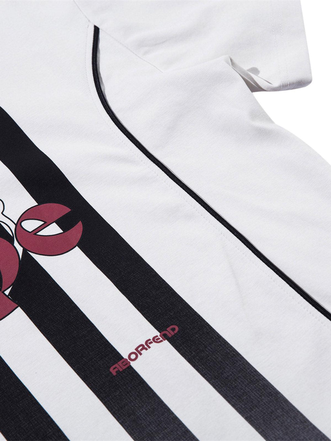 Detailed fabric and graphics on TALISHKO's striped jersey polo shirt, highlighting bold design.