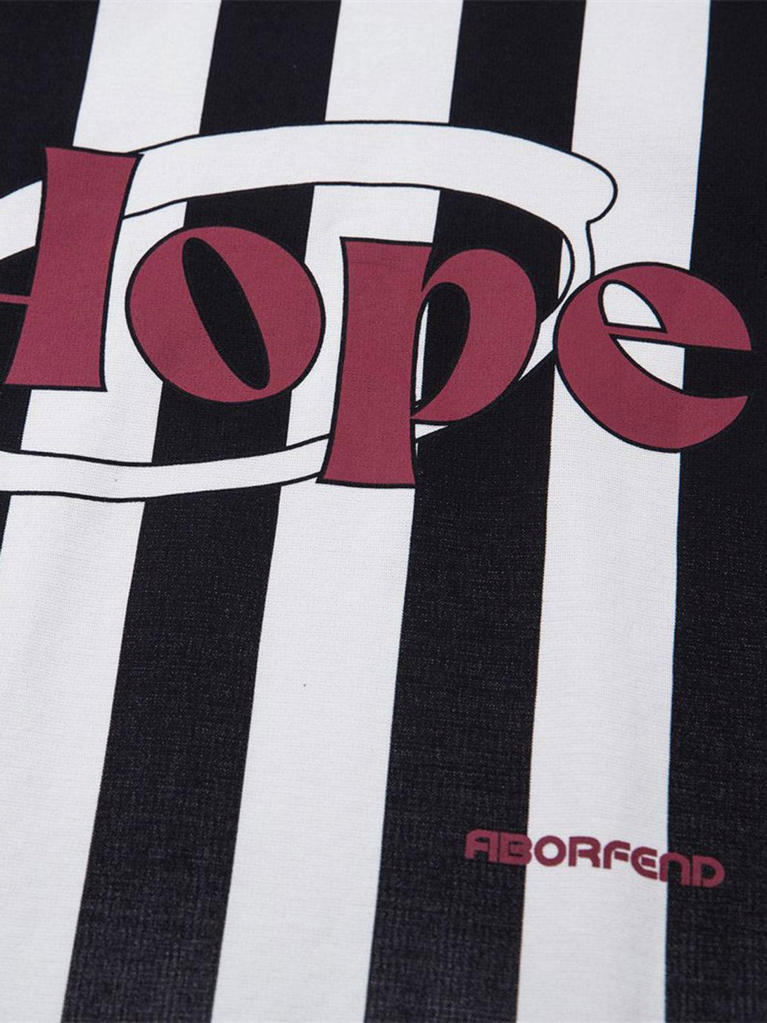 A focused look at TALISHKO's jersey polo shirt, showcasing bold graphics on black and white stripes.
