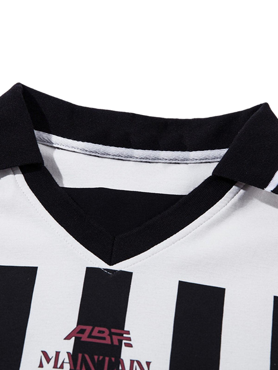 Detailed view of TALISHKO jersey polo shirt, highlighting black and white stripes and collar.