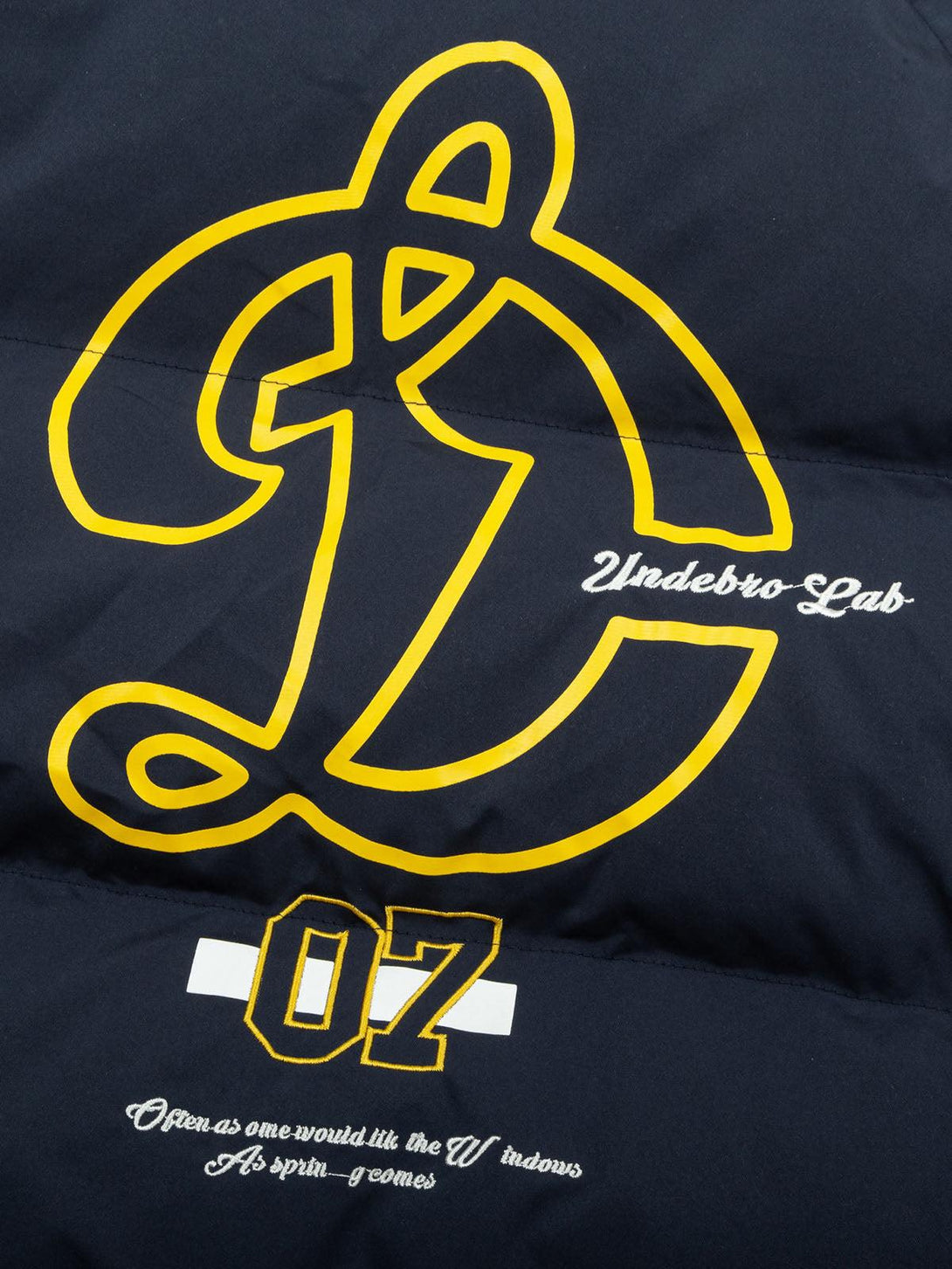 Bold graphic detail on a quilted puffer jacket by TALISHKO, highlighting unique embroidery.