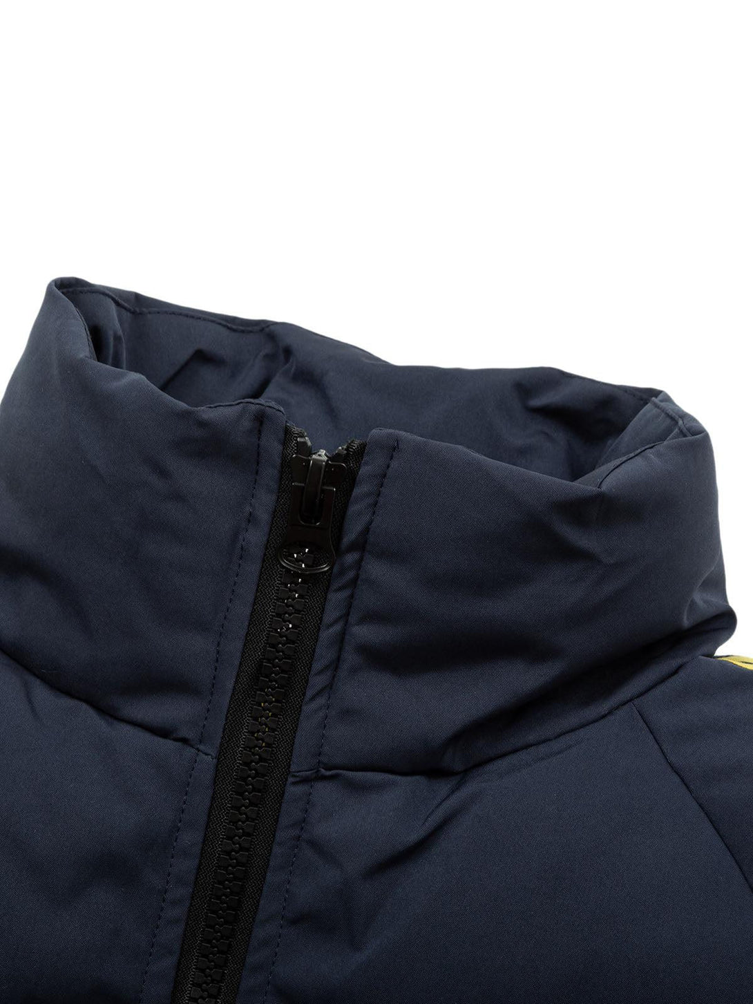 Focusing on the zippered stand collar of a quilted puffer jacket by TALISHKO, highlighting texture.