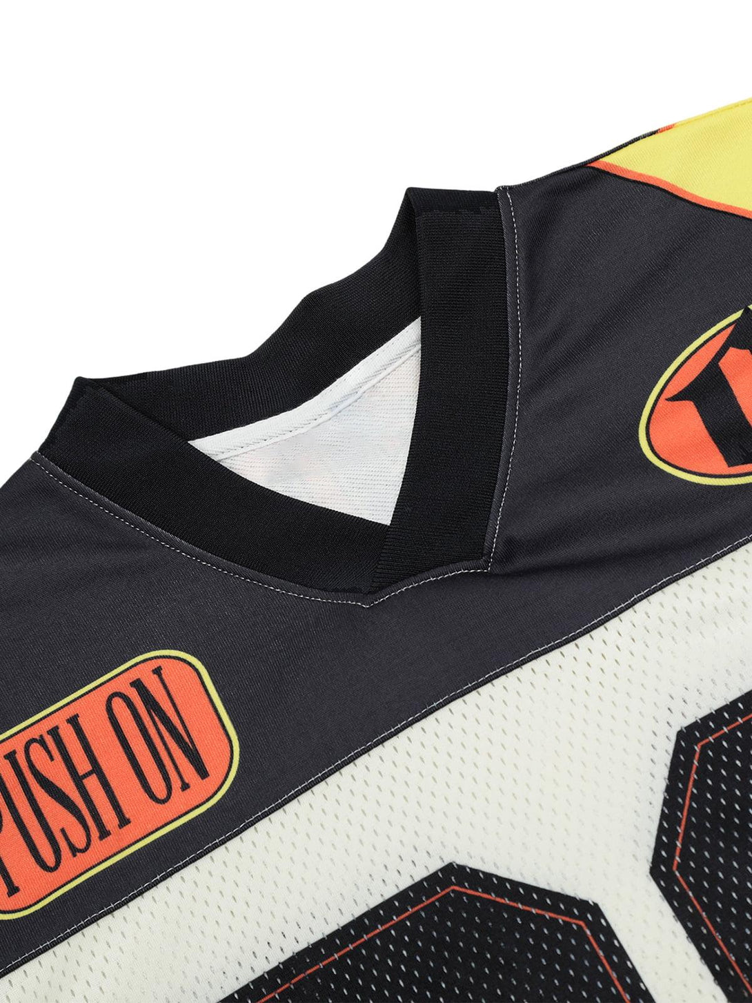 Focusing on the neckline and vibrant patch details of the jersey-style T-shirt by TALISHKO.