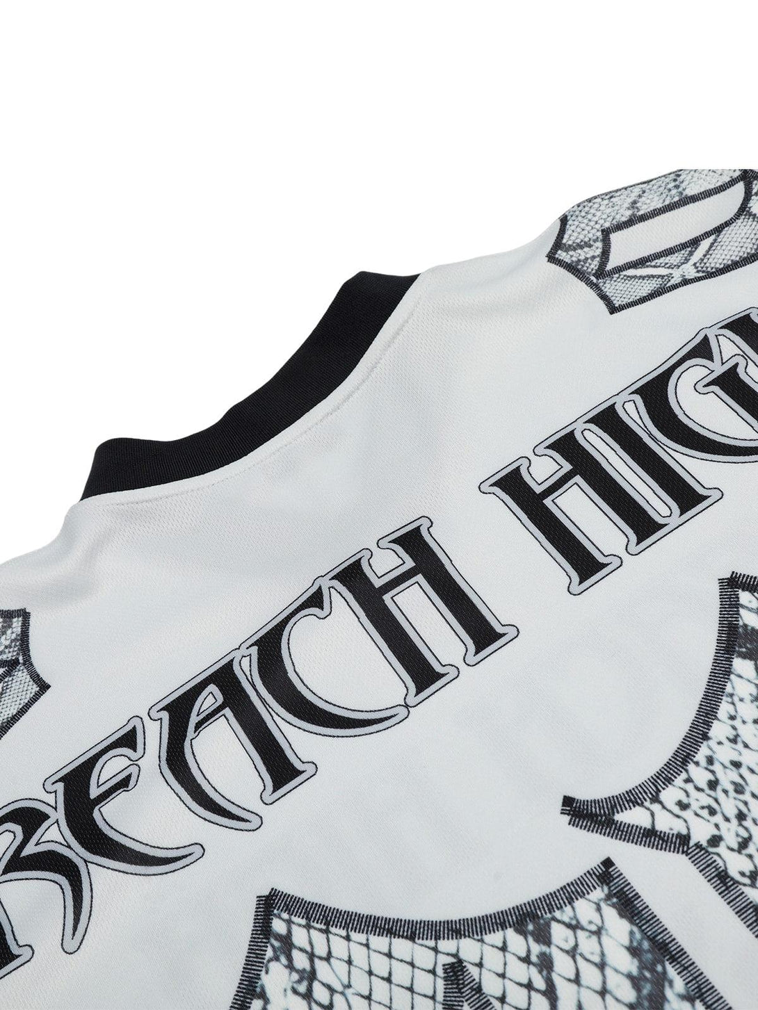 TALISHKO jersey-style T-shirt highlighting intricate "Reach High" text and graphic details.