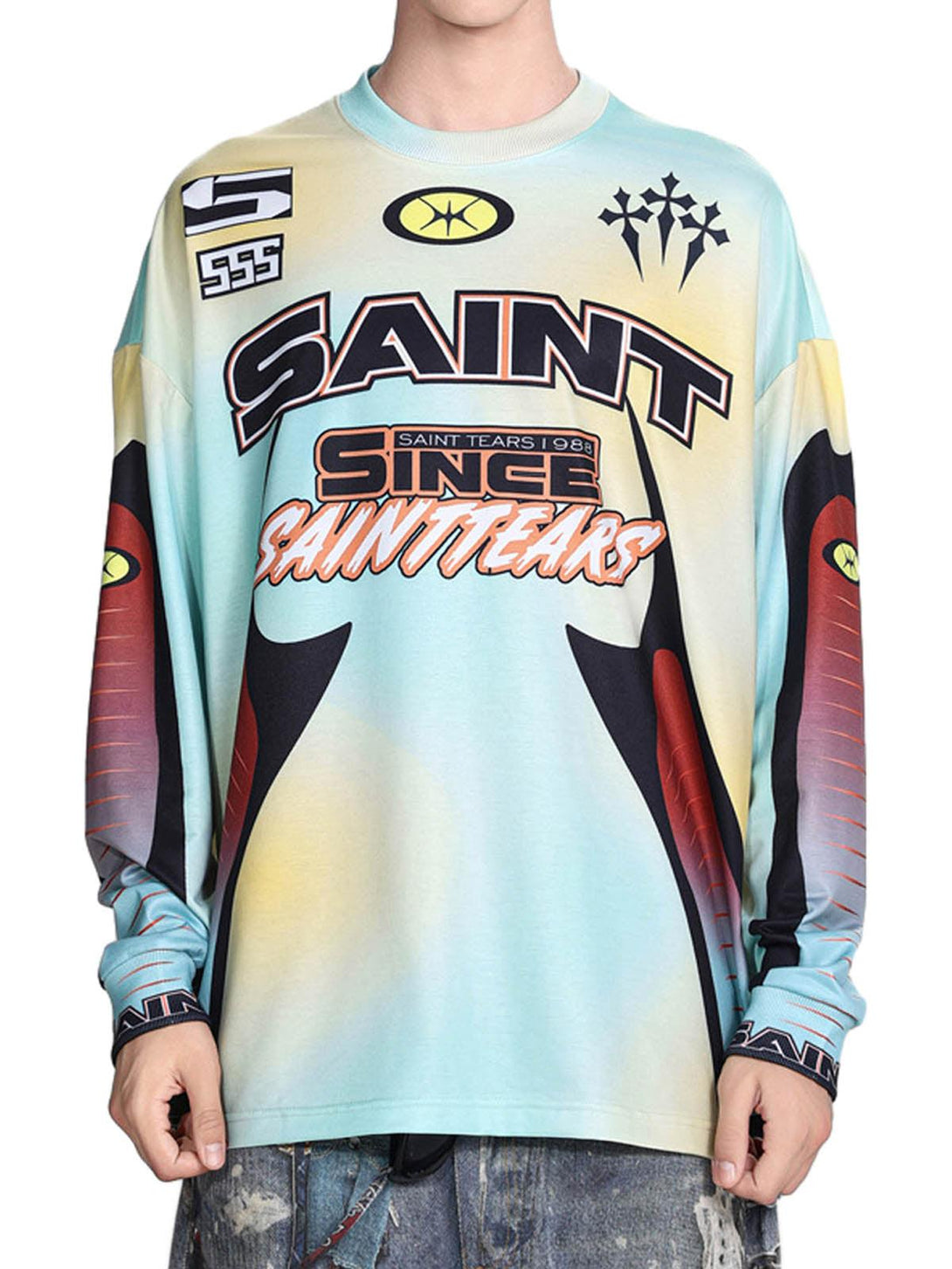 Model wearing TALISHKO's colorful tie-dye jersey long-sleeve T-shirt with bold graphics.