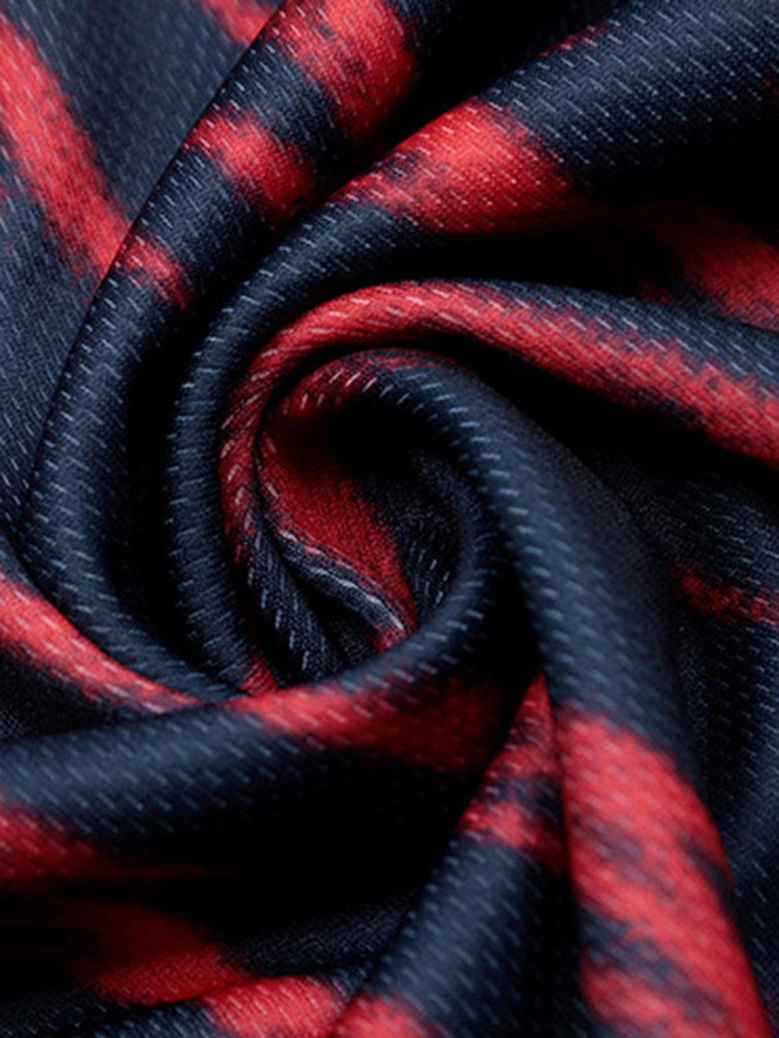 Zoomed-in texture of TALISHKO jersey's vibrant red and navy fabric pattern.