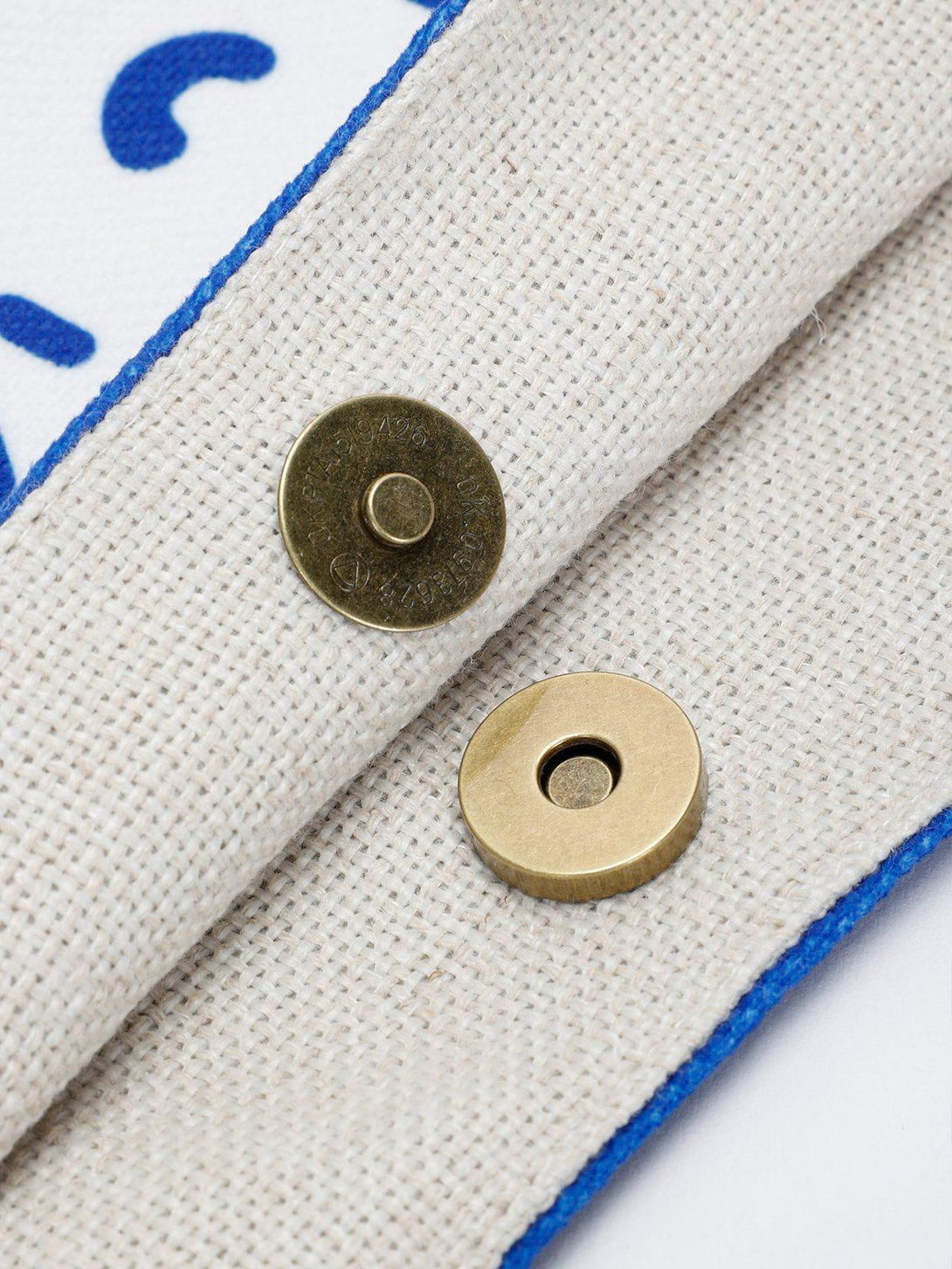 Close-up of the TALISHKO canvas bag's magnetic clasp, highlighting texture and craftsmanship.