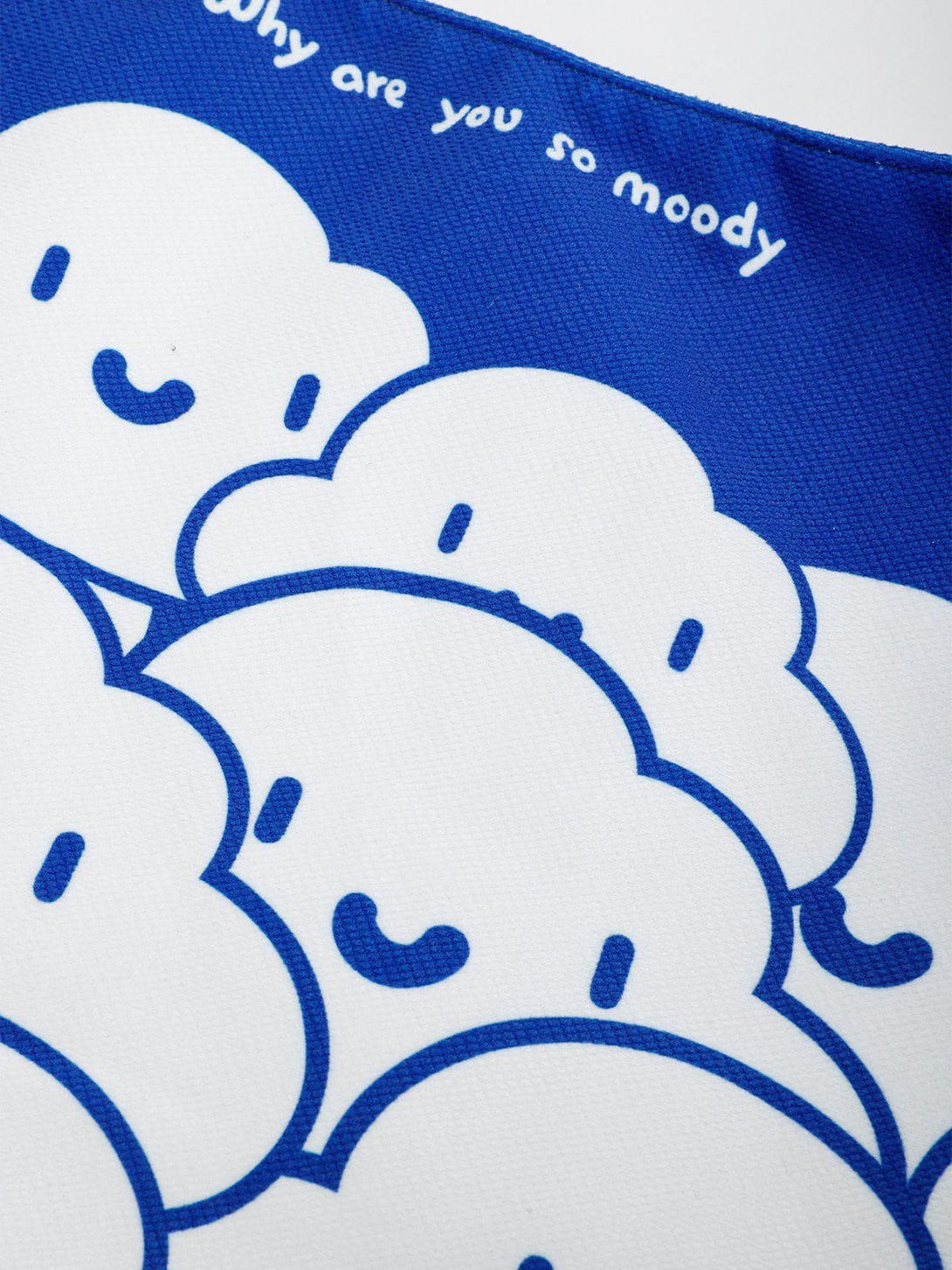 A detailed view of TALISHKO's Klein blue canvas bag showcasing a whimsical cloud pattern.