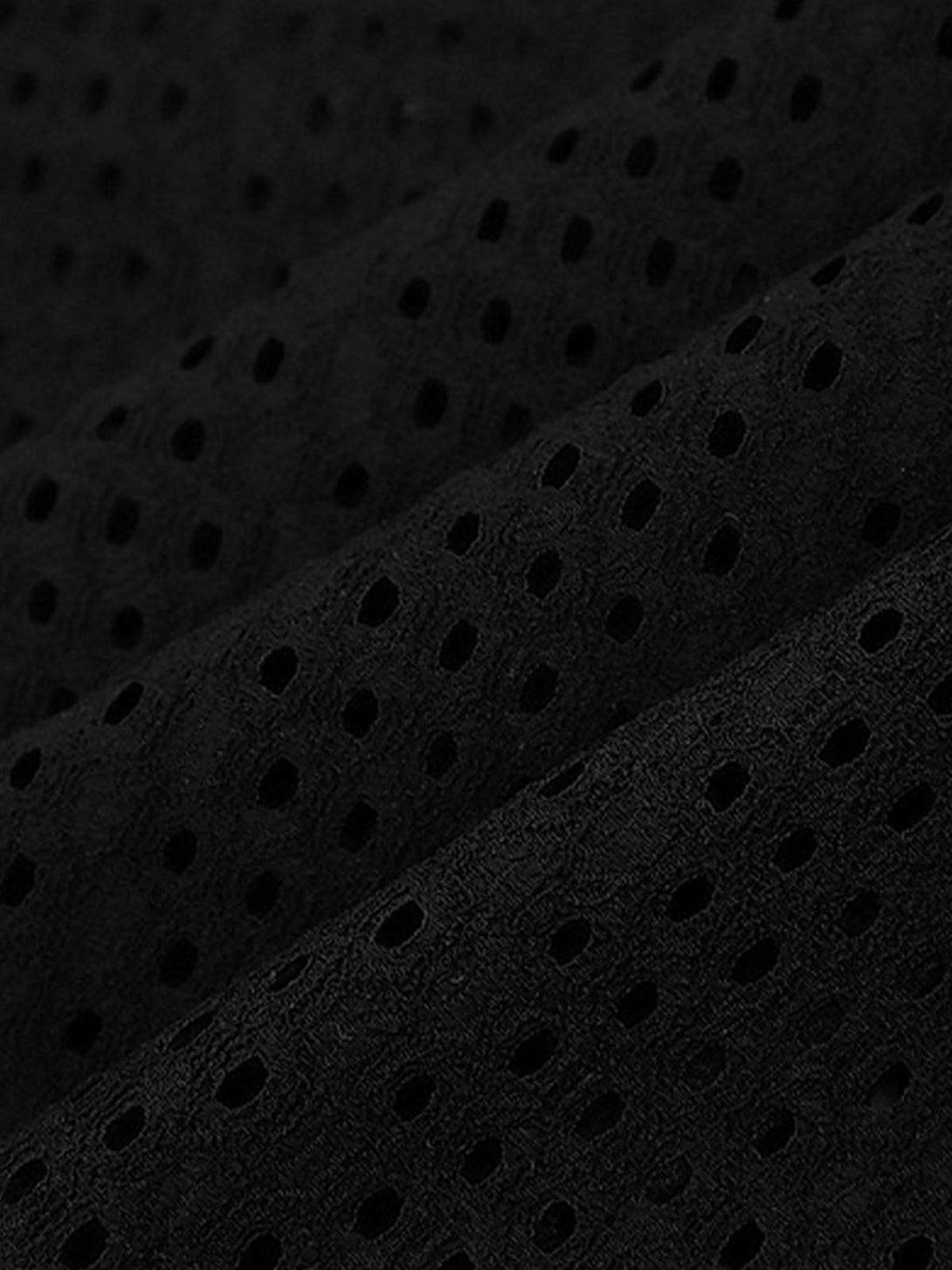A detailed view of the black hollow mesh knit texture by TALISHKO, showcasing intricate pattern.