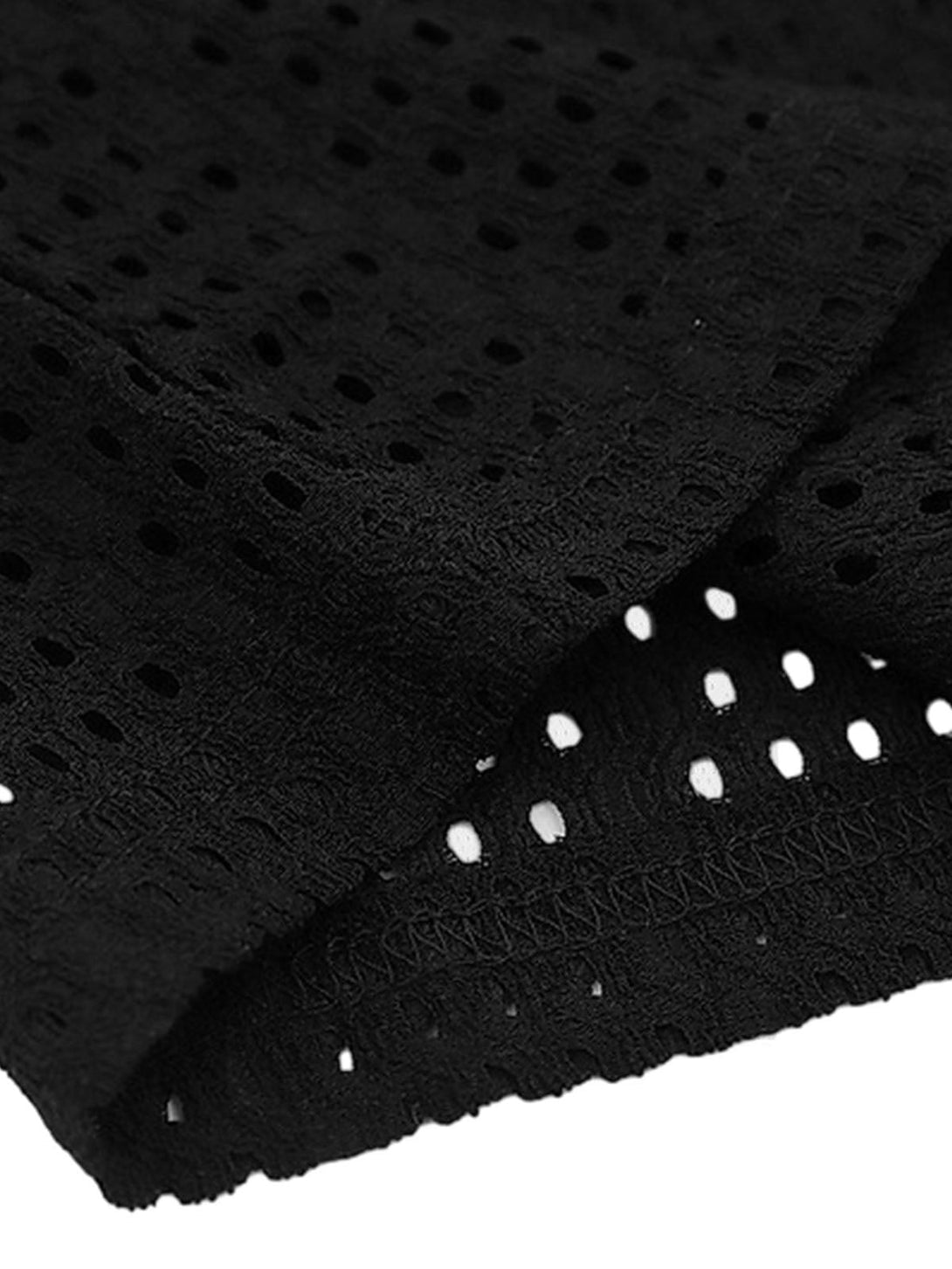 A close-up of the black knitted hollow mesh texture of a vest by TALISHKO, highlighting intricate detailing.