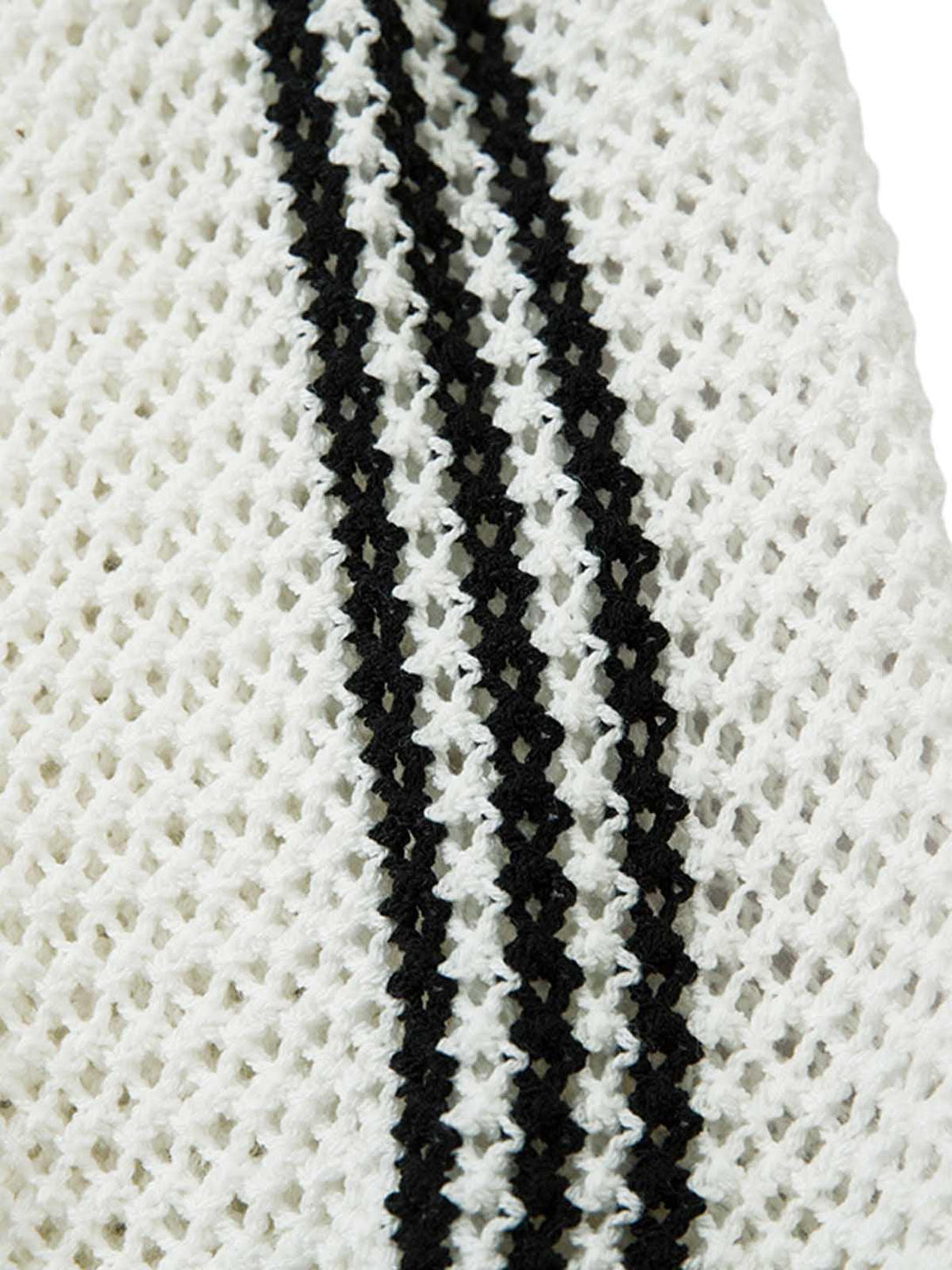 Zoomed-in texture of TALISHKO's knitted polo sweater, featuring bold black stripes.