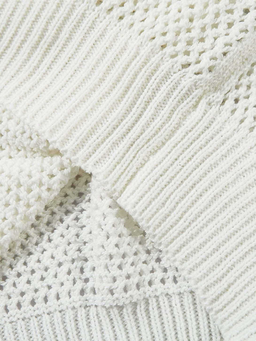 Intricate look at TALISHKO's knitted polo sweater, highlighting the textured fabric design.