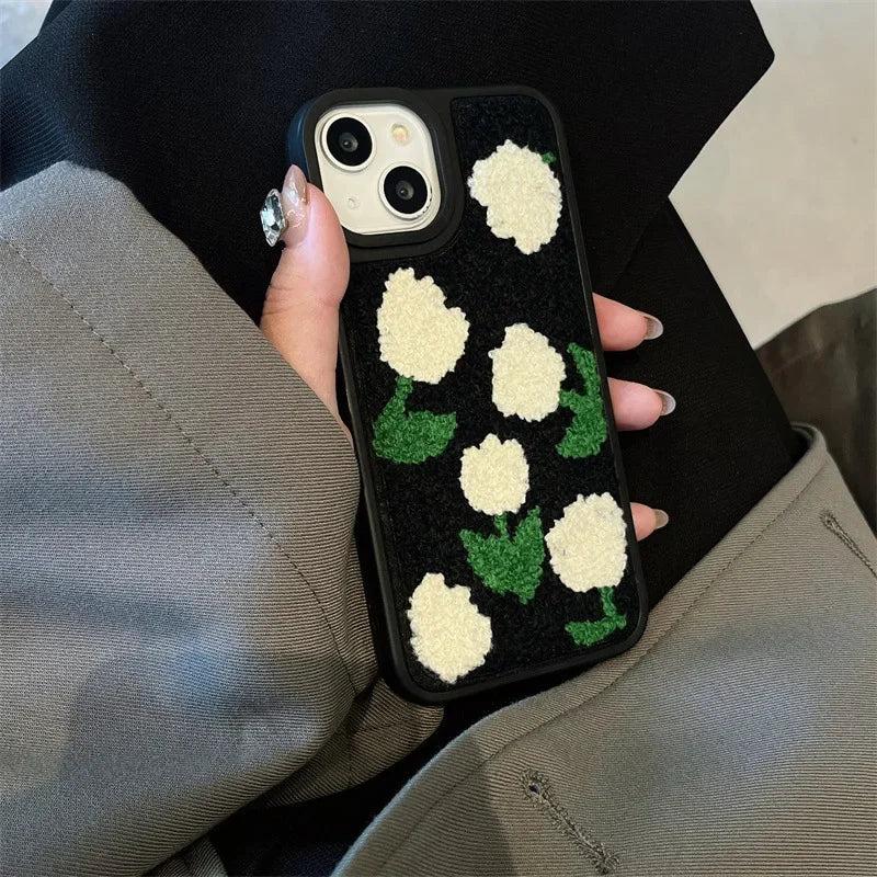 TALISHKO iPhone case featuring plush white floral design on a black background, held in hand.