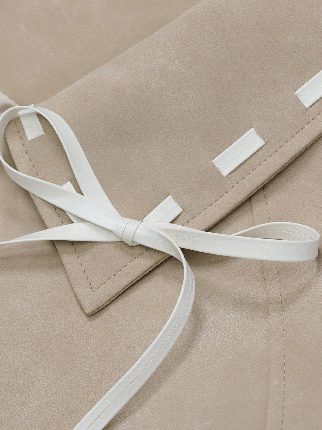 A detailed view of TALISHKO's faux leather jacket highlighting the elegant lace patchwork.