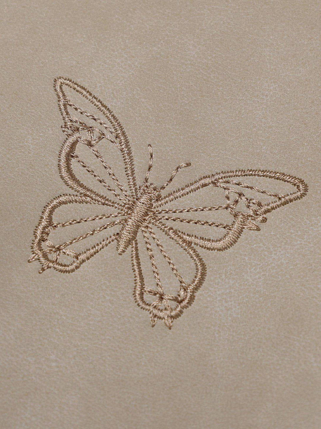 Intricate look at butterfly embroidery detail on TALISHKO faux leather jacket.