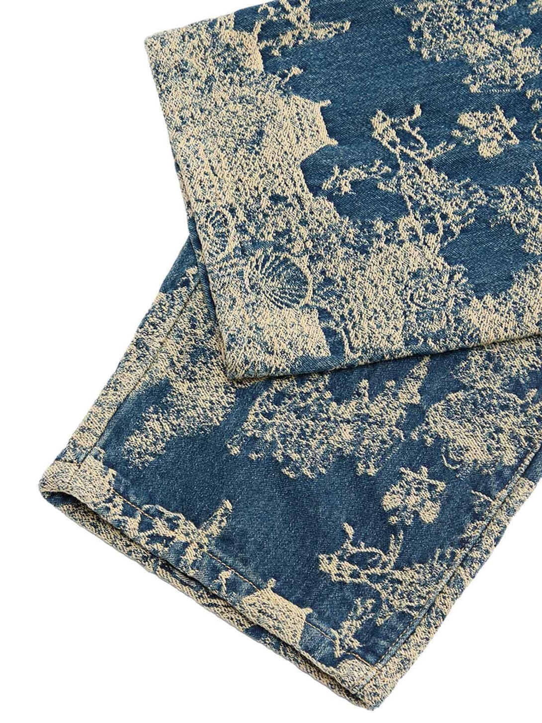 A detailed view of TALISHKO's landscape jacquard pattern on straight jeans, showcasing texture.