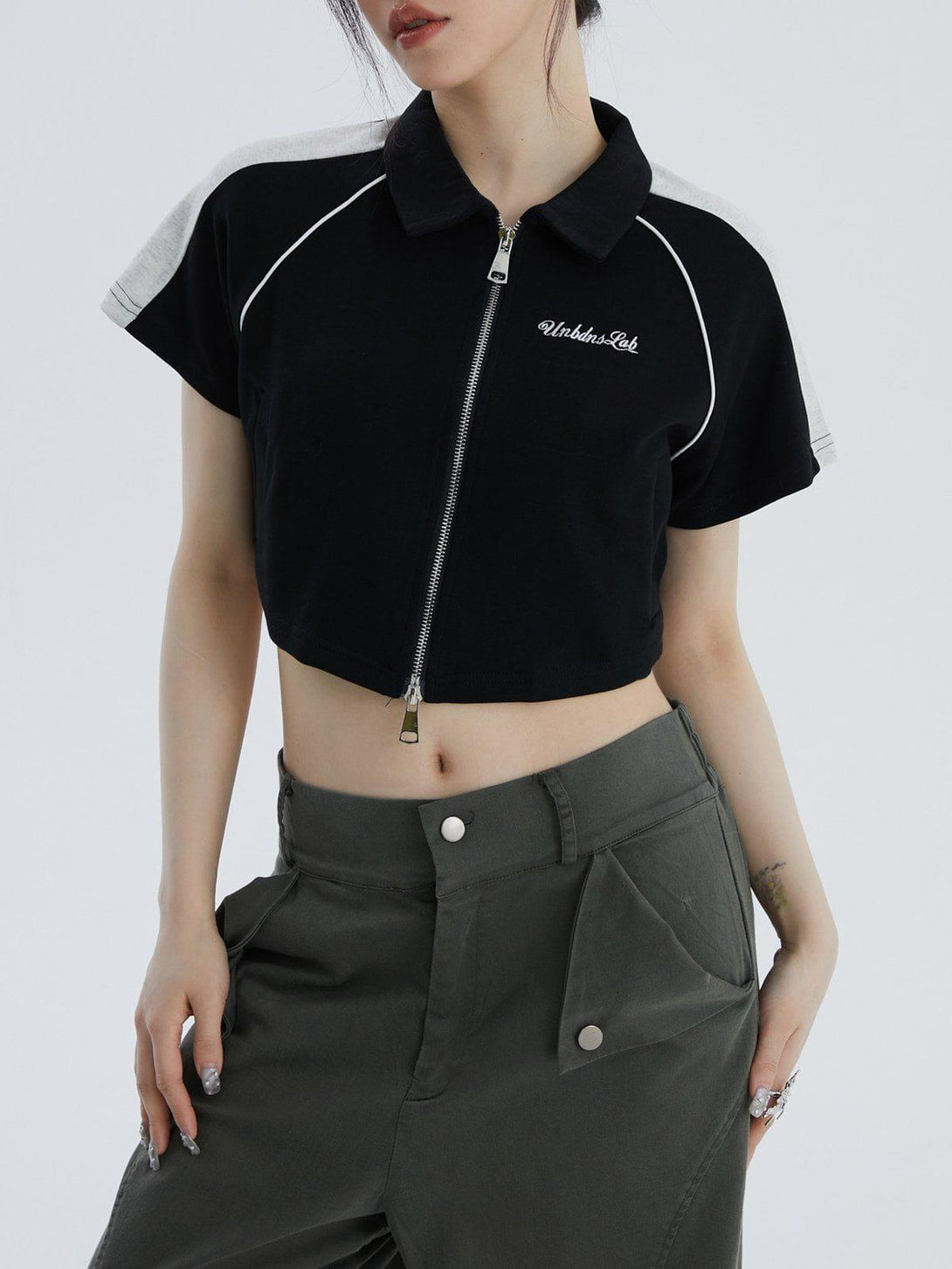 Model wearing a TALISHKO lapel zipper colorblock tee paired with high-waisted pants.